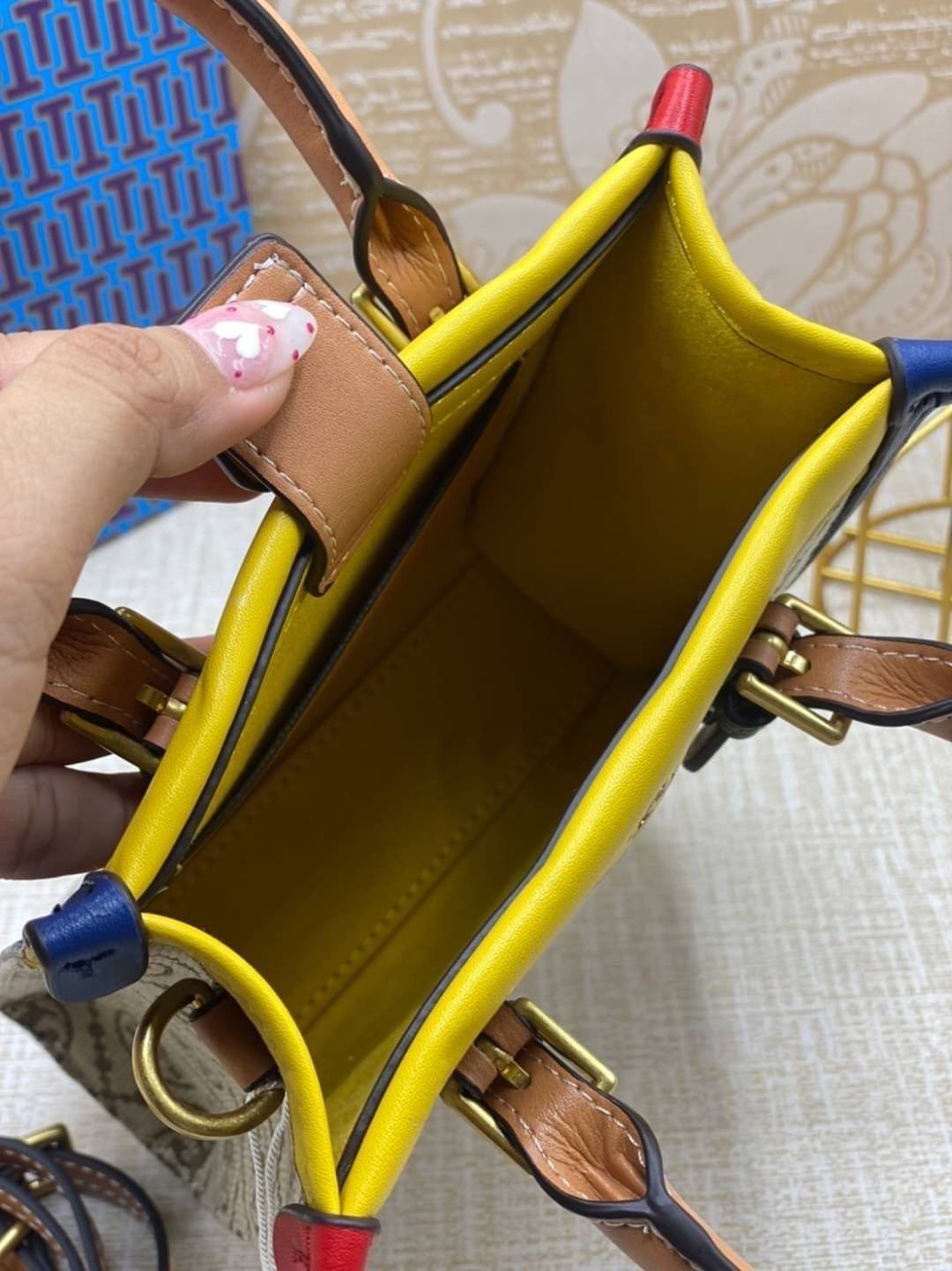 TORY BURCH T MONOGRAM COLORBlOCK JACQUARD MINI TOTE คอลเลคชั่นใหม่ล่าสุด ครอบครองก่อนใคร ไอเท็มยุคนี้รุ่นที่ควรมีติดตู้คะสาวๆ วัสดุ jacquard สลับหนังแท้ หูจับ มาพร้อมสายสะพายข้างหนังแท้ ปรับระดับได้ สายสามารถถอดออกได้ ภายในเป็นช่องโล่ง ใส่มือถือได้ กระเป๋