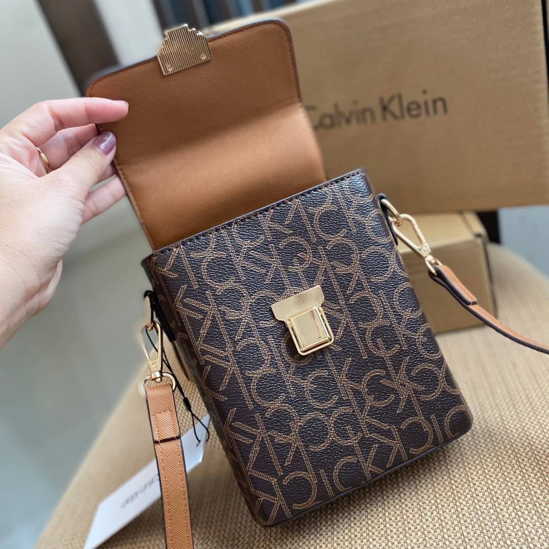 CALVIN KLEIN JEANS crossbody bag กระเป๋าถือหรือสะพาย ลายซิกเนเจอร์แบรนด์ทั้งใบ มีหูจับสำหรับถือ เปิด-ปิดกระเป๋าด้วยกระดุมแม่เหล็ก ด้านในโล่งกว้างมีช่องเล็กและช่องซิปสำหรับใส่ของจุกจิก ซับในลายแบรนด์อย่างดี มาพร้อมสายสะพายยาวปรับระดับได้ สามารถใช้ได้หลากหล