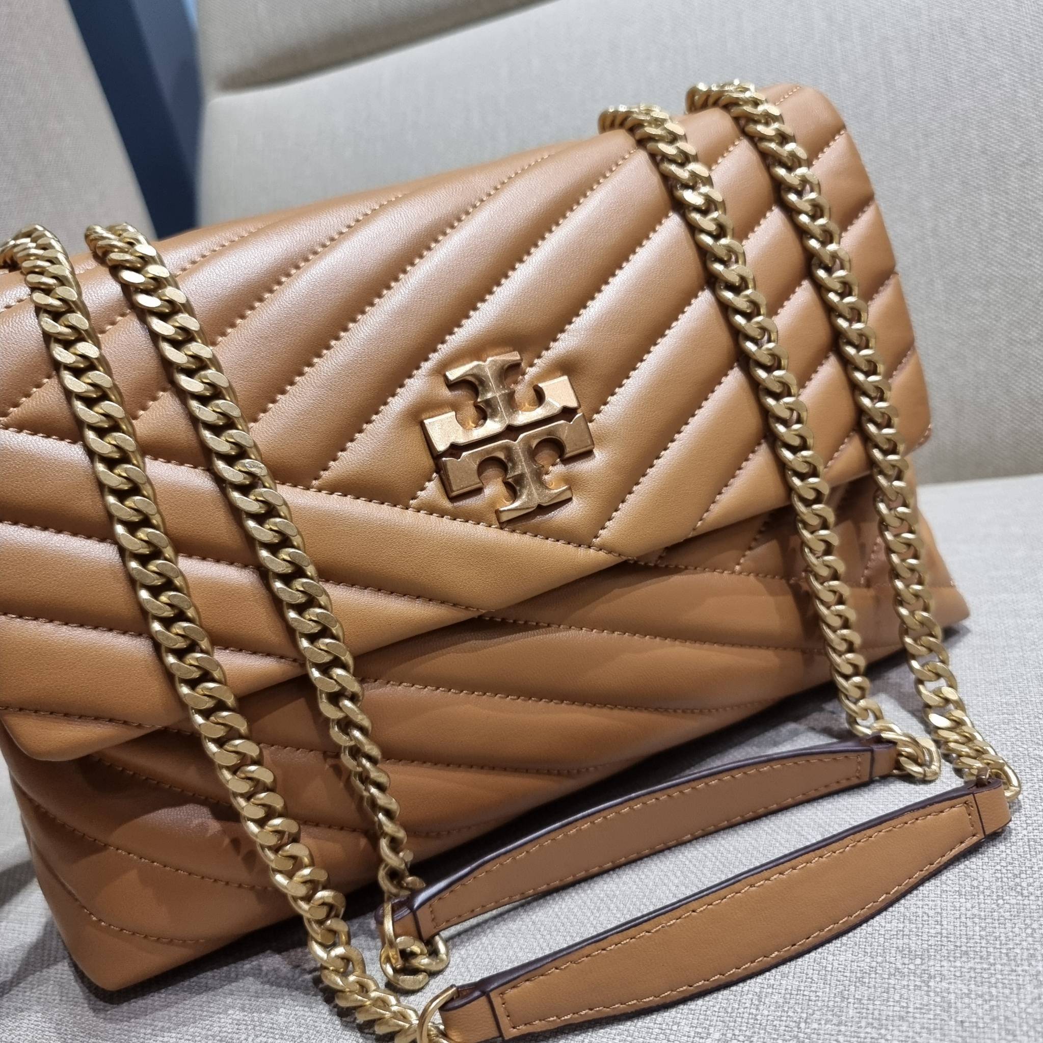 TORY BURCH KIRA CHEVRON CONVERTIBLE SHOULDER BAG กระเป๋าสะพายรุ่นยอดฮิต ไซส์ใหญ่จัดเต็มให้เน้นๆ ใช้ยังไงก็ดูหรู ดีไซน์เฉพาะตัว วัสดุหนังแกะ สัมผัสนิ่ม เปิด-ปิดด้วยกระดุมแม่เหล็ก ภายในเป็นช่องโล่ง แบ่งสัดส่วนไว้ดีมากๆ ใส่กระเป๋าสตางค์ มือถือ เครื่องสำอางค์
