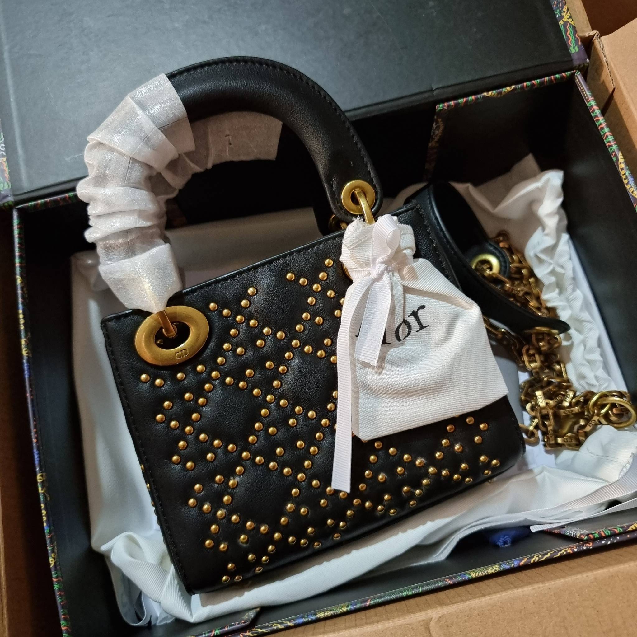 DIOR CD MINI LADY STUDDED BAG กระเป๋าสะพายข้างพรีเมี่ยมกิ๊ฟสุดฮอต ดีไซน์ตกแต่งหมุดเต็มใบ ไม่มีคือพลาด หรูจริงอะไรจัง ทรงกล่องคลาสสิค วัสดุหนังแท้ โดดเด่นด้วยพวงกุญแจโลโก้สีทองลิมิเต็ด มีหูจับในตัวและสายครอสบอดี้สุดเลิศ แต่งเติมดีเทลอัพราคาไปอีก ภายในเป็นช