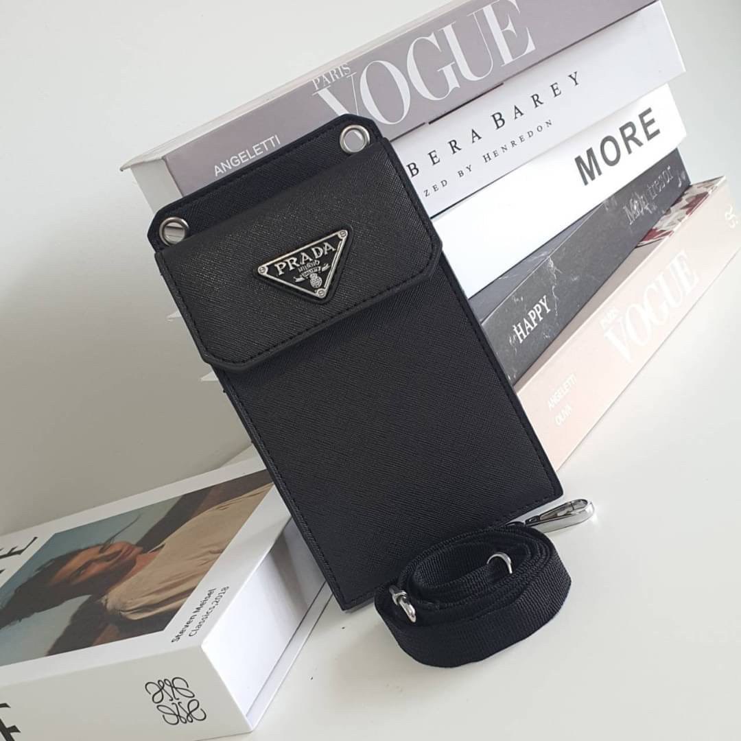 PRADA PHONE CASE ไอเท็มสุดคลาสสิคที่ทุกท่านควรมี! Prada Saffiano Leather Smartphone Case งานพรีเมี่ยมกิ้ฟท์จากเคาเตอร์ต่างประเทศ ของมีจำนวนจำกัด หนังลาย saffiano อยู่ทรงสวย ดีไซน์หรูหรา ดูดี ทรงCrossbody ด้านหน้ามีโลโก้แบรนด์ อะไหล่ทอง ด้านในเปิดปิดด้วยกร