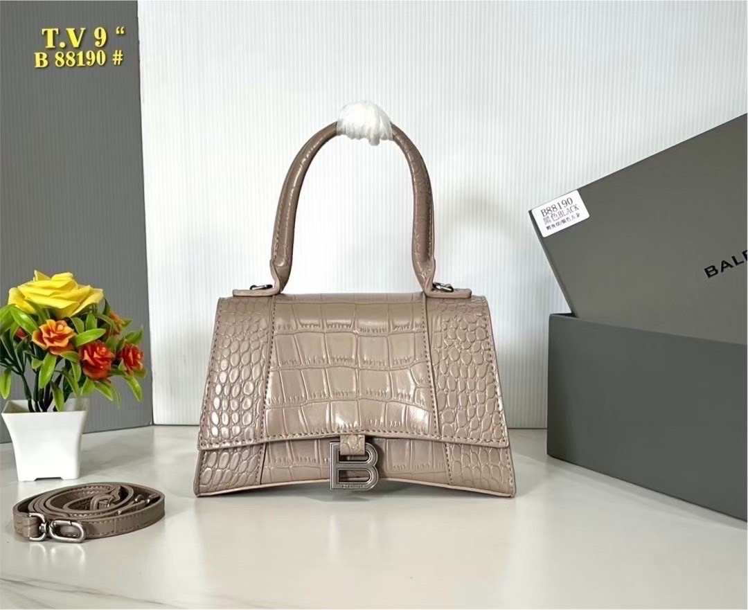 BALENCIAGA Hourglass top-handle tote bag กระเป๋าสะพายแบรนด์หรูซิกเนเจอร์ ที่มาพร้อมดีไซน์โดดเด่น มีความโฉบเฉี่ยว โค้งมนเหมือนพระจันทร์เสี้ยว เพิ่มความสวยสะดุดตาด้วยการตกแต่งอักษร B เมทัลลิก