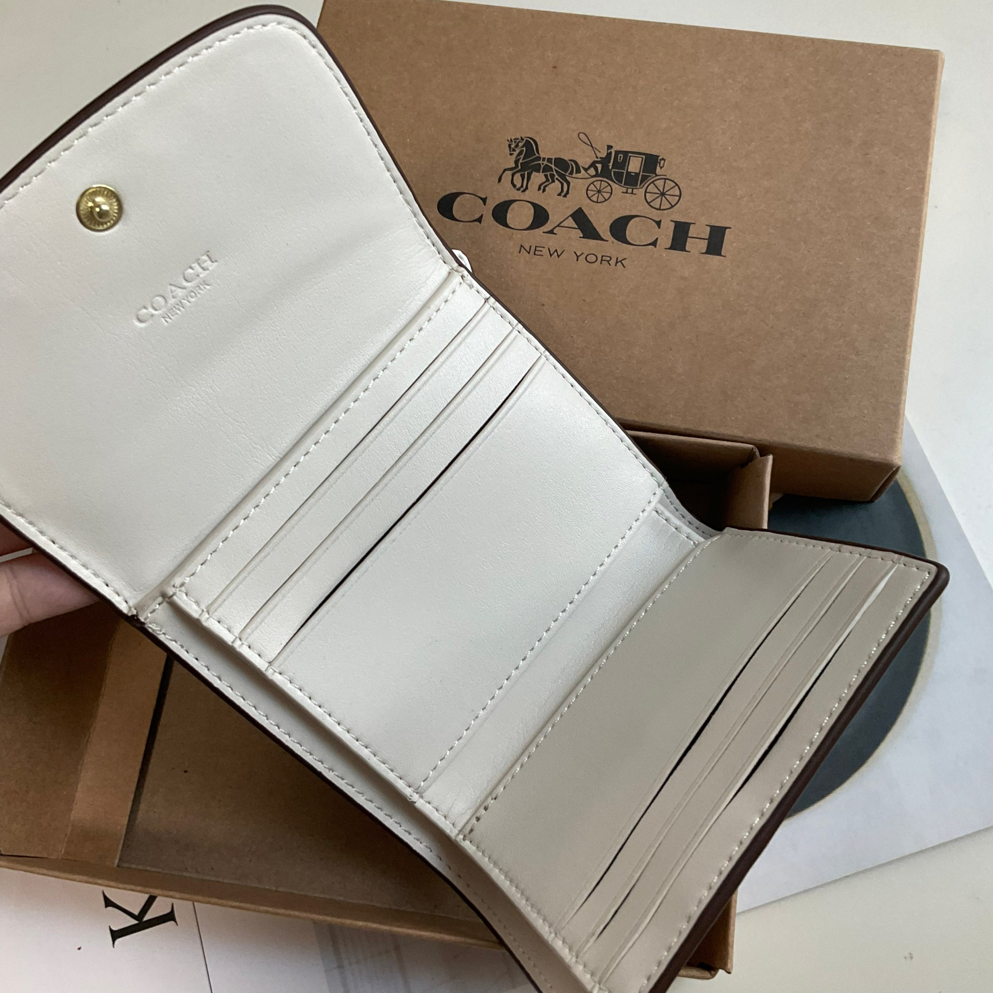COACH SMALL WALLET IN SIGNATURE CANVAS กระเป๋าสตางค์ใบสั้น แบบพับสามตอน เปิดปิดด้วยกระดุมปั้มแบรนด์ ด้านในมีช่องใส่บัตรหลายช่อง และช่องใส่ธนบัตร ด้านหลังมีช่องซิปเหรียญอีกหนึ่งช่อง น้ำหนักเบา พกพาสะดวก อะไหล่เงาสุดหรู ห้ามพลาดค่ะ!