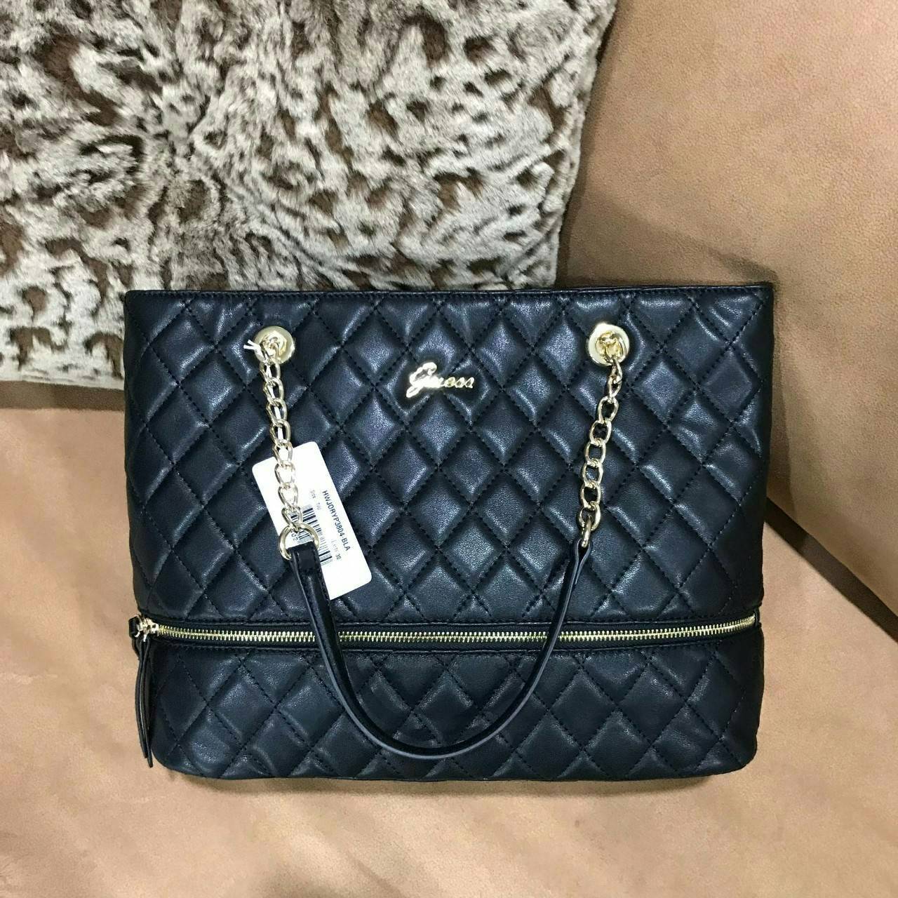 GUESS WOMEN’S SHOPPER BAG WITH ZIPS (SIZE L) กระเป๋าสะพายรุ่นใหม่ล่าสุดจาก GUESS FACTORY ลายตารางข้าวหลามตัดหนังนิ่มสวยอยู่ทรงไม่ย้วยขนาดใหญ่กำลังดี ด้านหน้าประดับโลโก้ พร้อมแต่งซิปดูมีดีเทล หูหิ้วสะพายไหล่โซ่ต่อหนังเเข็งแรงรับน้ำหนักได้เยอะ เปิดปิดด้วยซิ