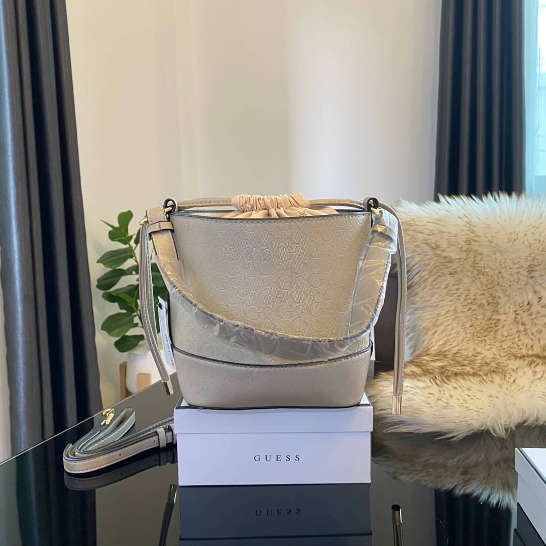 Guess Agata Bucket Handbag กระเป๋ารุ่นใหม่ล่าสุดทรงถังสุดน่ารัก พิมพ์ลายรอบใบ วัสดุ Saffiano PU คุณภาพดี นิ่ม น้ำหนักเบา ด้านหน้าประดับด้วยโลโก้แบรนด์สวยโดดเด่น เปิด-ปิดด้วยเชือกหนังใช้หูรูดปลายเชือกประดับอะไหล่ทองสะดวกใช้ ด้านในโล่งกว้างมีช่องเล็กสำหรับใ