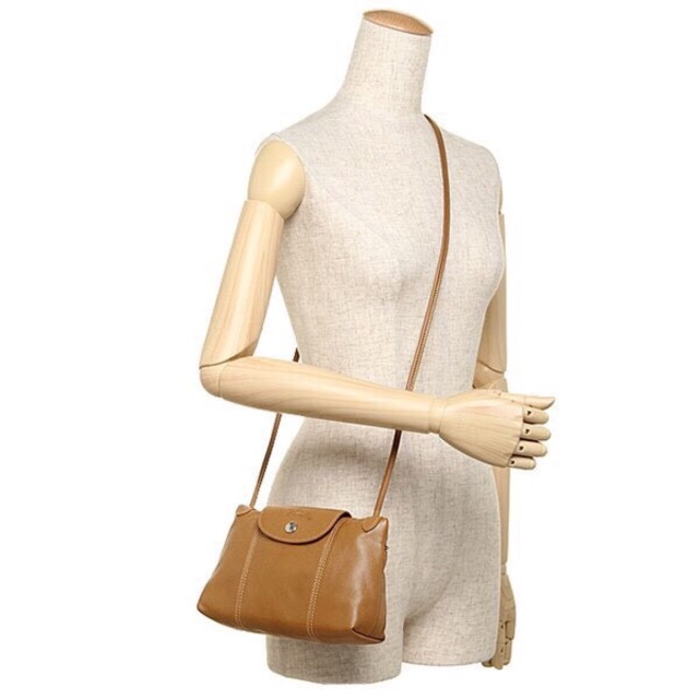 Longchamp Le Pliage Cuir Crossbody Bag อีกหนึ่งคอลเลคชั่น Le Pliage Cuir หนึ่งในตระกูลกระเป๋าสุดไอคอนิกจากแบรนด์ Longchamp และจัดการปรับดีไซน์ให้มีขนาดเล็กลงในทรงcrossbody กะทัดรัดสะพายแล้วคล่องตัว ด้วยดีไซน์ที่ดูเป็นเอกลักษณ์การใช้งานช่องหลักที่ซิปด้านหล