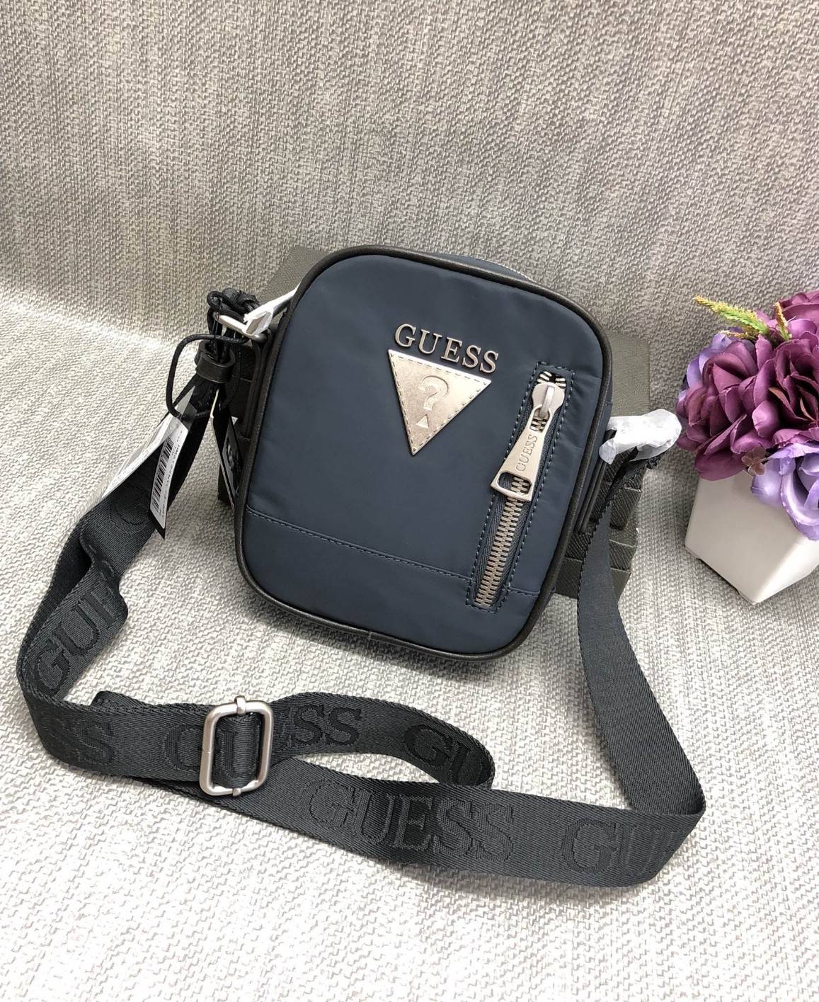 New GUESS SHOULDERBAG HM 6122 พร้อมส่งกระเป๋าสะพาย รุ่นนี้ใช้ได้ทั้งชาย/หญิง วัสดุไนล่อนอย่างดี คุณภาพสูง ด้านหน้าติดอะไหล่และโลโก้แบรนด์ มีช่องซิปใส่ของจุกจิก เปิดปิดกระเป๋าช่องหลักแบบซิป ด้านในโล่ง ลึก ใส่มือถือ กระเป๋าสตางค์ใบสั้นหรือสัมภาระอื่นๆได้พอป