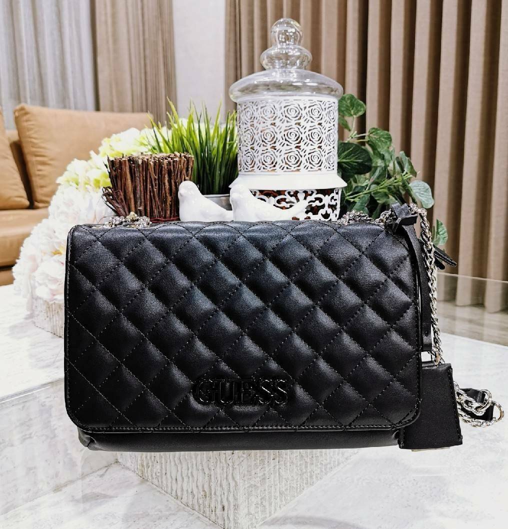 GUESS CROSSBODY BAG กระเป๋าสะพายรุ่นใหม่ล่าสุดทรงเหลี่ยมหนังนิ่มสวยเดินเส้นลายตารางอยู่ทรงด้านหน้าประดับโลโก้ GUESS สวยดูมีเปิดปิดด้วยฝาปิด ภายในมีช่องแบ่งสองช่องเป็นสัดส่วนใส่กระเป๋าสตางค์ใบยาว มือถือ ของจุกจิกได้เยอะ พร้อมสายสะพายโซ่ต่อหนังจะเลื่อนใช้สา