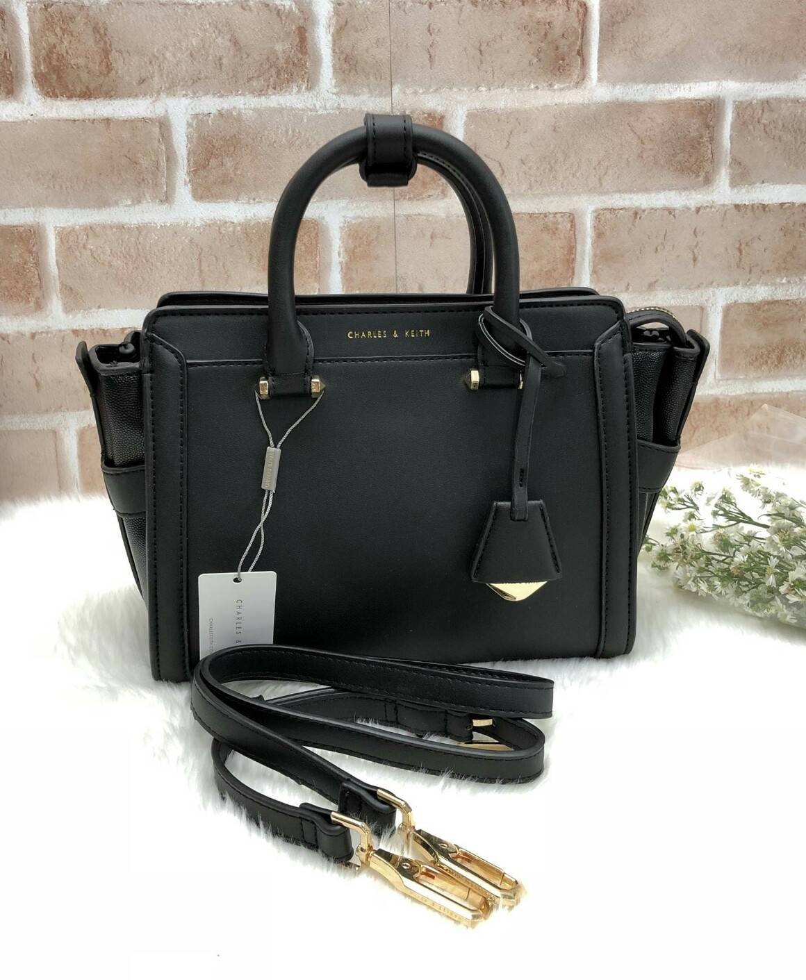 CHARLES & KEITH TRAPEZE BAG (หนังเรียบ) กระเป๋าถือหรือสะพายรุ่นยอดนิยมดีไซน์สวยหรู - วัสดุหนังลายคาร์เวียร์ สวยอยู่ทรง - ด้านข้างเเต่งช่องตัดดูมีดีเทล - ด้านหน้าสกรีนโลโก้ ด้านหลังมีช่องซิป - เปิดปิดด้วยซิปหัวซิปปั๊มโลโก้ หูจับเเข็งแรง พับลงได้