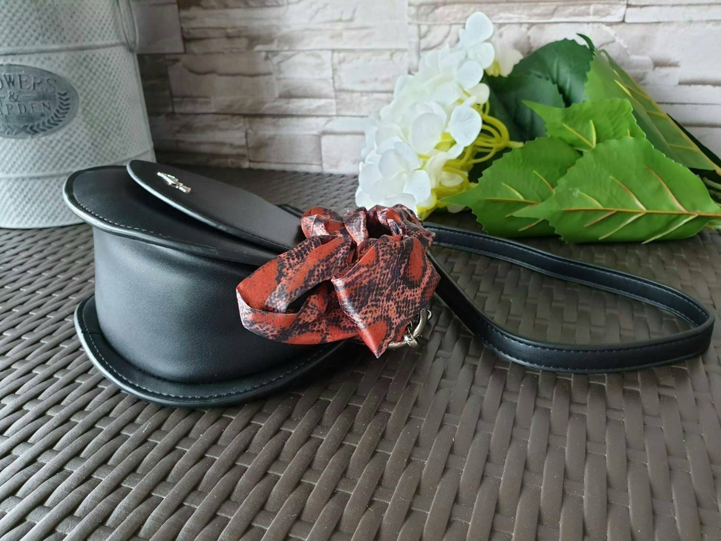 CHARLES & KEITH รุ่น LEATHER SATIN SCARF CROSSBODY BAG SL2-50150828 ราคาปกติช้อป ( ฿3,590.00 ) กระเป๋าถือ และ สะพาย ทรงโค้งมน หนังเรียบ ตั้งอยู่ทรง ด้านหน้าติดโลโก้แบรนด์ อะไหล่เงิน หูจับสายกระเป๋าร้อยเข้ากับห่วงเหล็กกลมๆ ด้วยผ้าลายสวยงามผูกเป็นโบว์เก๋ๆ ถ