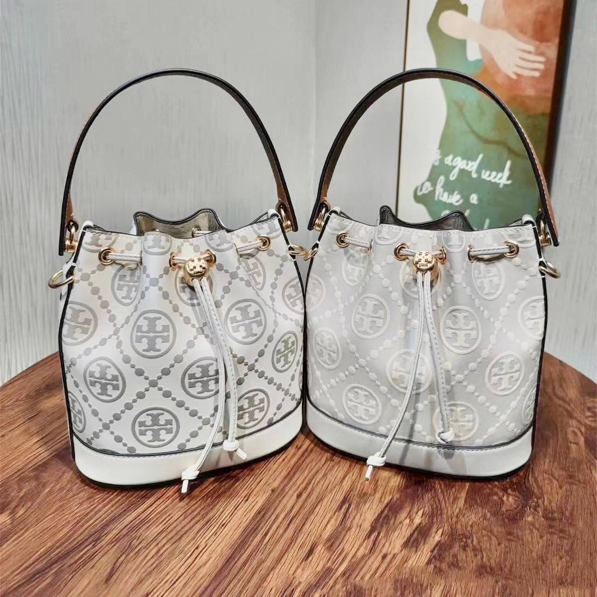 Medium : Tory Burch T Monogram Embossed Bucket Bag กระเป๋าถือหรือสะพายไหล่ ประดับด้วยลวดลายอันเป็นสัญลักษณ์ของแบรนด์ ถูกประดิษขึ้นด้วยความพิถีพิถันวัสดุหนังอย่างดี ด้านในบุด้วยหนังไมโครซูแอคเนื้อนุ่มทำความสะอาดง่าย กระเป๋าผ่าหลังด้านนอก1ช่อง ด้านใน 1ช่อง 