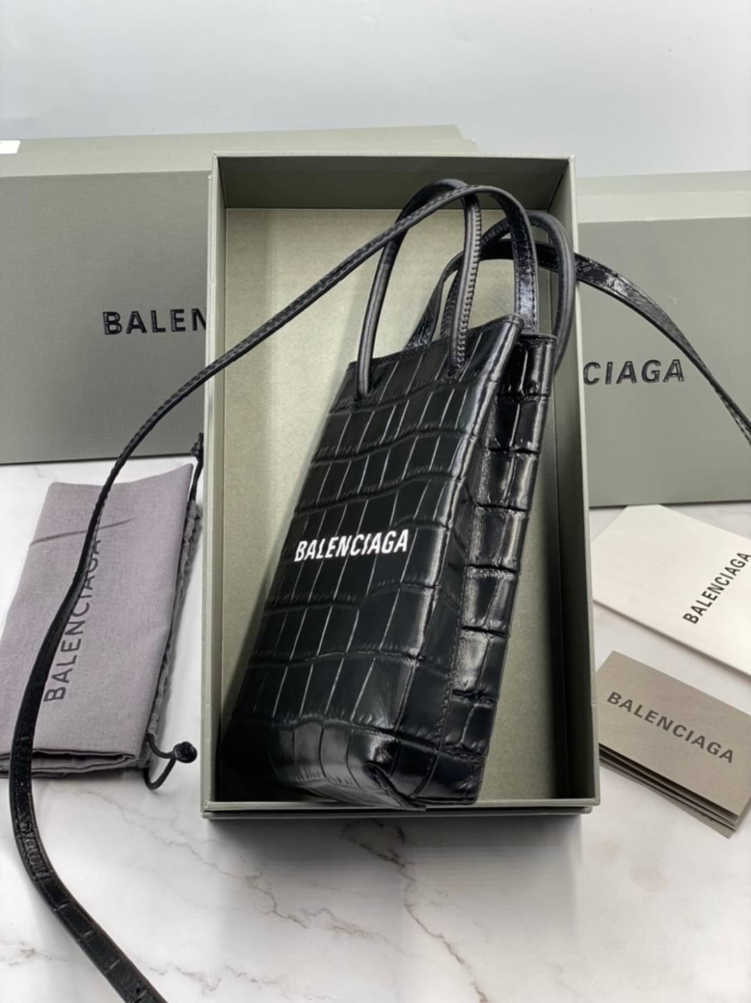 หนังแท้ BALENCIAGA Shopping Phone Pouch leather tote พกกระเป๋าช้อปปิ้งขนาดมินิ ไปทุกที่ในฤดูกาลนี้ ดีไซน์ที่ใช้ได้ทุกวันตั้งแต่หนังแบบมีเท็กซ์เจอร์ ภาพสินค้าถ่ายจากงานขายจริง ใช้งานต่างประเทศได้
