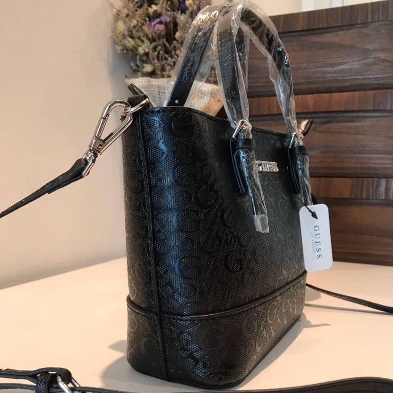 GUESS MINI CROSS BODY BAG กระเป๋าถือหรือสะพายรุ่นฮิตและขายดีที่สุดจาก GUESS FACTORY วัสดุหนังแก้วเงาสวยอยู่ทรง น้ำหนักเบา ด้านหน้าประดับด้วยโลโก้แบรนด์สุดหรูพร้อมปอมๆห้อยที่หูกระเป๋าถอดเเยกใช้ได้ เปิดปิดกระเป๋าด้วยซิปสะดวกใช้ ด้านในโล่งกว้างมีช่องซิปและช่