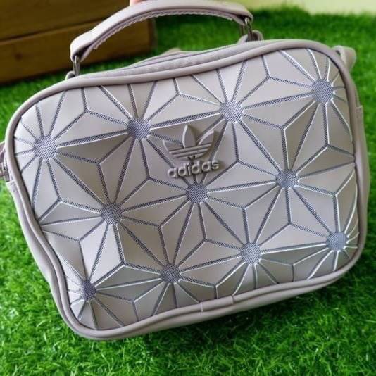 adidas mini airline bag *outlet* กระเป๋าสะพายข้างทรงสปอร์ต ด้านหน้าติดโลโก้แบรนด์ ดีไซน์ลาย 3D ด้านหลังเป็นหนังเรียบ มีช่องซิปสามารถใส่สิ่งของได้ รุ่นนี้เปิดปิดด้วยซิปคู่ ซิปปั๊มแบรนด์ทุกจุด ด้านในเป็นช่องกว้าง มีช่องซิป สายสะพายยาวสามารถปรับระดับได้ สาวก