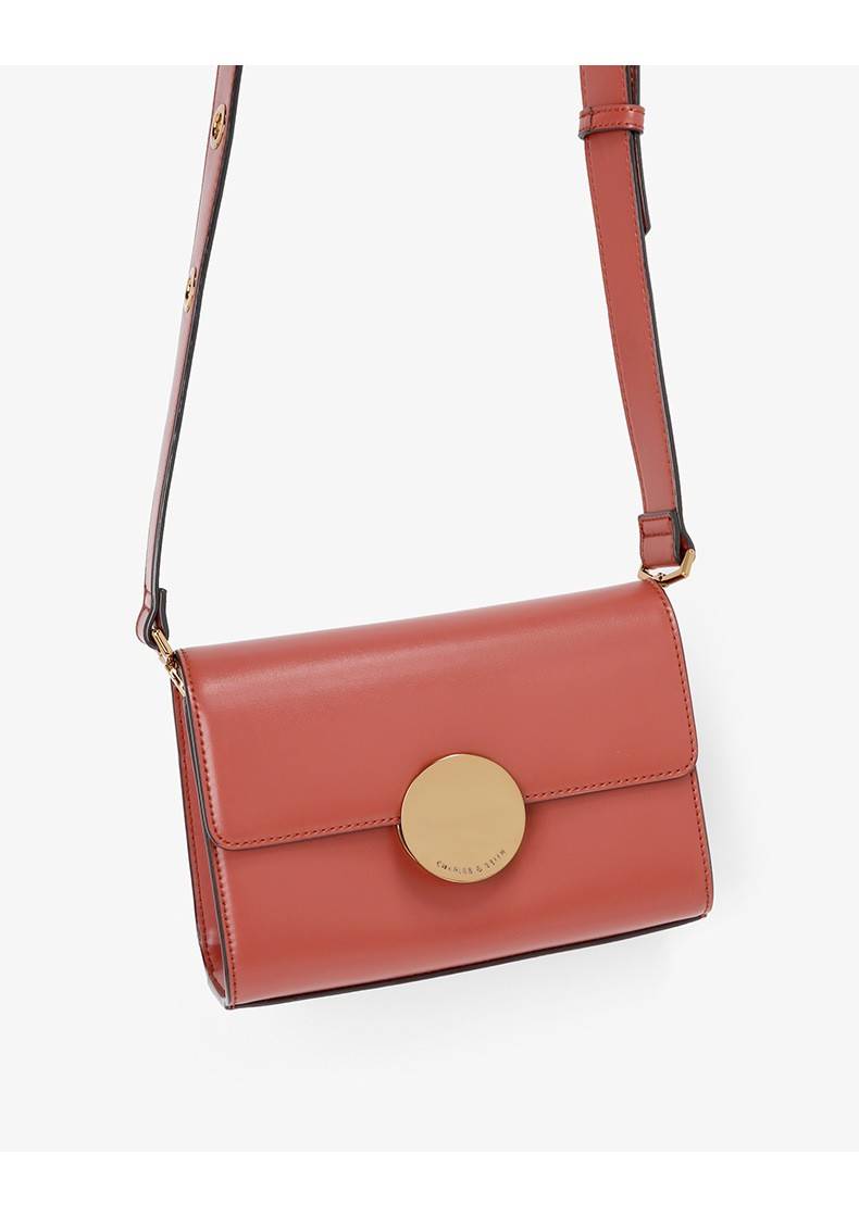 CHARLES AND KEITH CIRCULAR BUCKLE CROSSBODY BAG กระเป๋าสะพายครอสบอดีทรงคลัช ใบเล็กหนังเรียบสวย กระเป๋าสะพาย crossbody หนัง PU เรียบสวย สามารถถอดสายถือแบบคลัชได้ ด้านหน้าประดับด้วยตัวล็อค สุดเก๋ เป็นแผ่นกลมสีทองและสีเงิน ปั๊มแบรนด์ มาพร้อมสายสะพาย สามารถปร