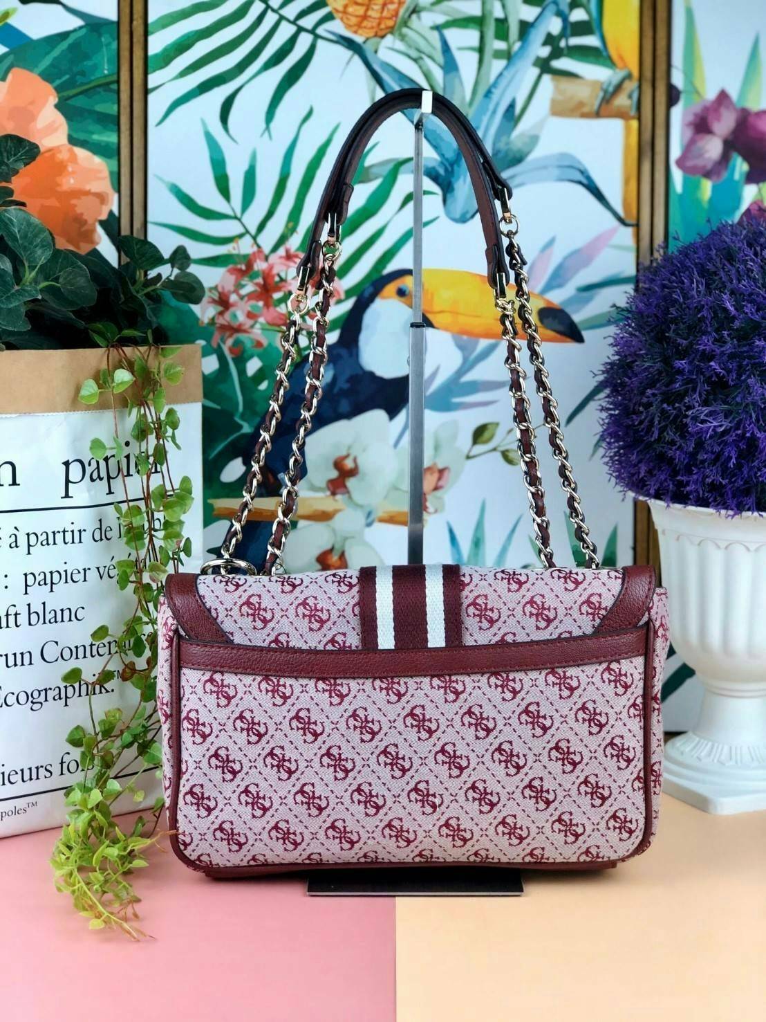 Guess Logo city handbag กระเป๋าสะพายไหล่ ตัวกระเป๋าเป็นผ้าลาย signature ของแบรนด์ ตัดกับหนังที่ตัวขอบกระเป๋า มาพร้อมพวงกุญแจโลโก้แบรนด์ ด้านหน้ามีโลโก้แบรนด์ ด้านหลังมีช่องใส่โทรศัพท์/บัตรได้ เปิดปิดแบบกระดุมแม่เหล็กซ้าย-ขวา ด้านในมีช่องซิป เล็ก 1 ช่อง แล