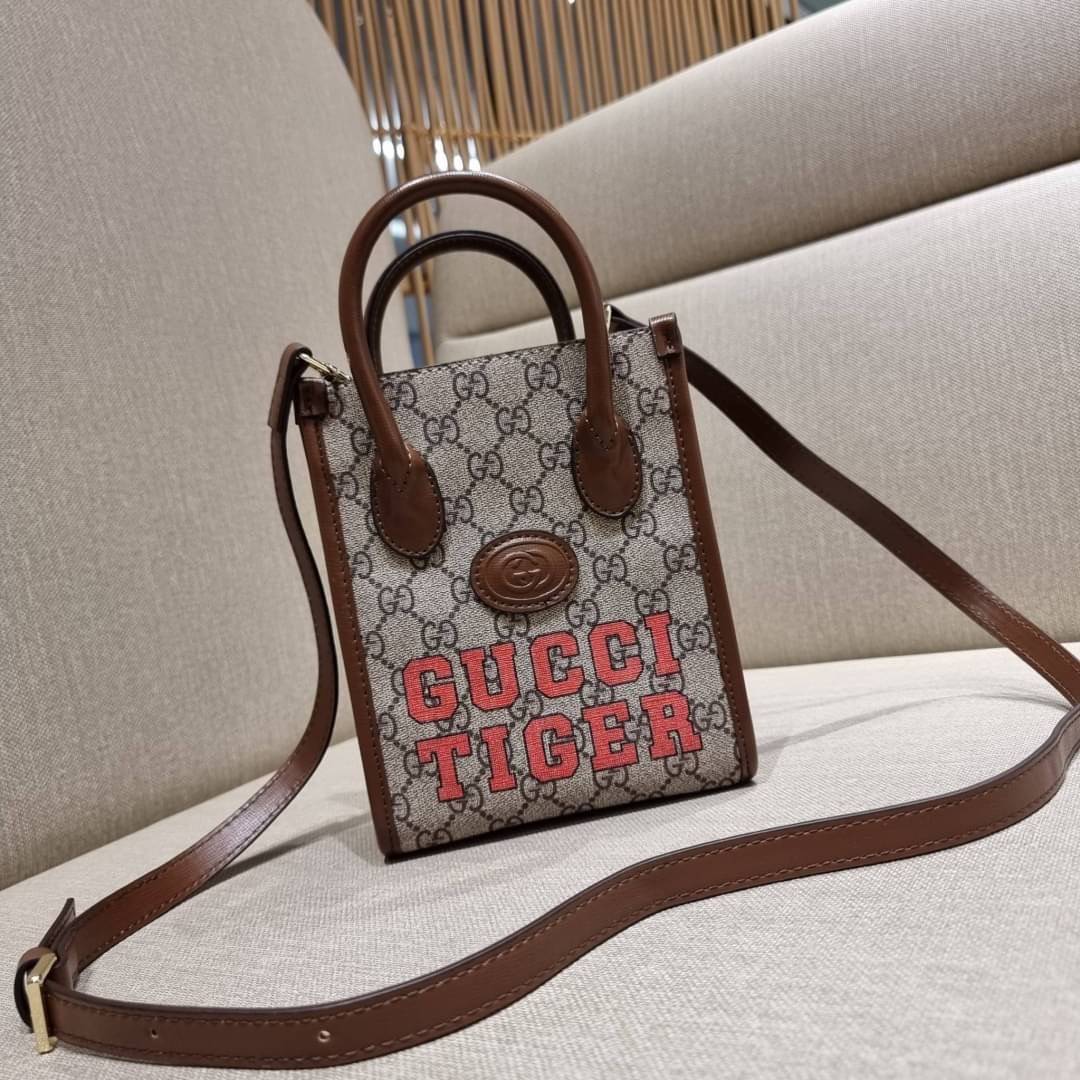 GUCCI Tiger GG mini tote bag ไซส์มินิ ร้อนแรงไฟลุก!! ต้อนรับปีเสืออย่างเป็นทางการ จัดให้แบบเลิศๆ กับกระเป๋าทรงโท้ท วีไอพีพรีเมี่ยมกิ๊ฟ ไซส์มินิ โดดเด่นด้วยฟอนท์ตัวใหญ่ สวยเอกลักษณ์ วัสดุหนังแคนวาสตัดขอบด้วยหนังแท้ ภายในเป็นช่องโล่ง ใส่ของจุกจิกได้ ใส่โทรศ
