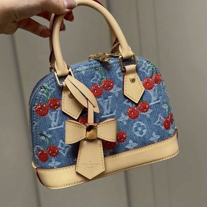 LV x TM Alma BB Monogram cherry denim 20cm กระเป๋าสะพายทรงโดม อัพลุคไฮน์ ขนาดกำลังดี หูจับในตัวใช้งานได้สะดวก โดดเด่นมีชีวิตชีวา ด้วยเดนิมวินเทจปักลายเชอร์รี่สีสันสดใสสะดุดตาสะท้อนสไตล์ไอคอนิก