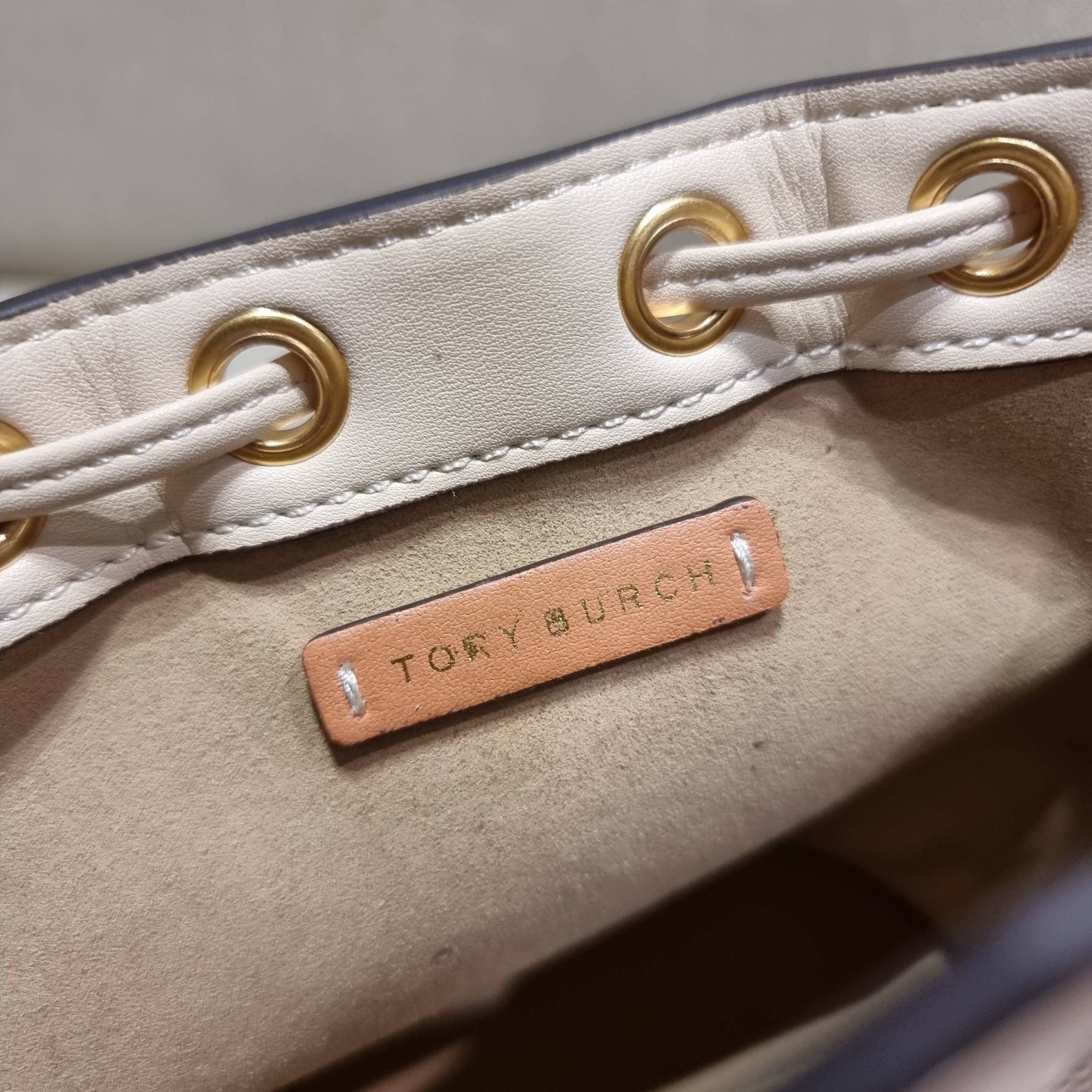 TORY BURCH MINI T MONOGRAM FLORAL BUCKET BAG คอลเลคชั่นใหม่ พร้อมเสิร์ฟความสวยให้ถึงบ้าน!! กระเป๋าบัคเก็ตทรงยอดนิยม ไซส์มินิ ดีไซน์ใหม่ล่าสุด สไตล์งานคราฟ มีลูกเล่นประดับดอกไม้กับตัวกระเป๋า และตัวรูดสาย วัสดุผ้า jacquard ตัดสลับหนังแท้ หูจับและขอบกระเป๋าต