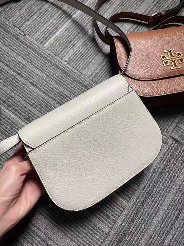 TORY BURCH BRLTTEN SMALL SADDLE BAG / Tory Burch Britten Flap Shoulder Bag กระเป๋าสะพายข้าง วัสดุหนังแกะแท้ ด้านหน้าประดับโลโก้แบรนด์ เปิด-ปิดกระเป๋าแบบกระดุมแป็กแม่เหล็กแน่นหนา ภายในมีช่องหลัก ใส่กระเป๋าเงินใบกลาง มือถือได้ทุกรุ่น มีช่องแยกใส่ของจุกจิกอี