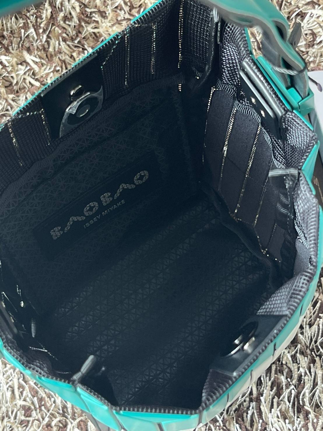 Small : BAO BAO ISSEY MIYAKE SMALL BUCKET เป็นกระเป๋าบัคเก็ตขนาดเล็กสามารถใช้ใส่กระเป๋าสตางค์และโทรศัพท์มือถือได้ ซีรีย์ใหม่นี้มีจุดเด่นที่แผ่นรูปทรงสี่เหลี่ยมด้านขนานในแนวตั้ง เกิดเป็นรูปทรงสามมิติซึ่งแตกต่างไปจากรูปทรงที่เกิดขึ้นจากแผ่นสามเหลี่ยม หูหิ้ว