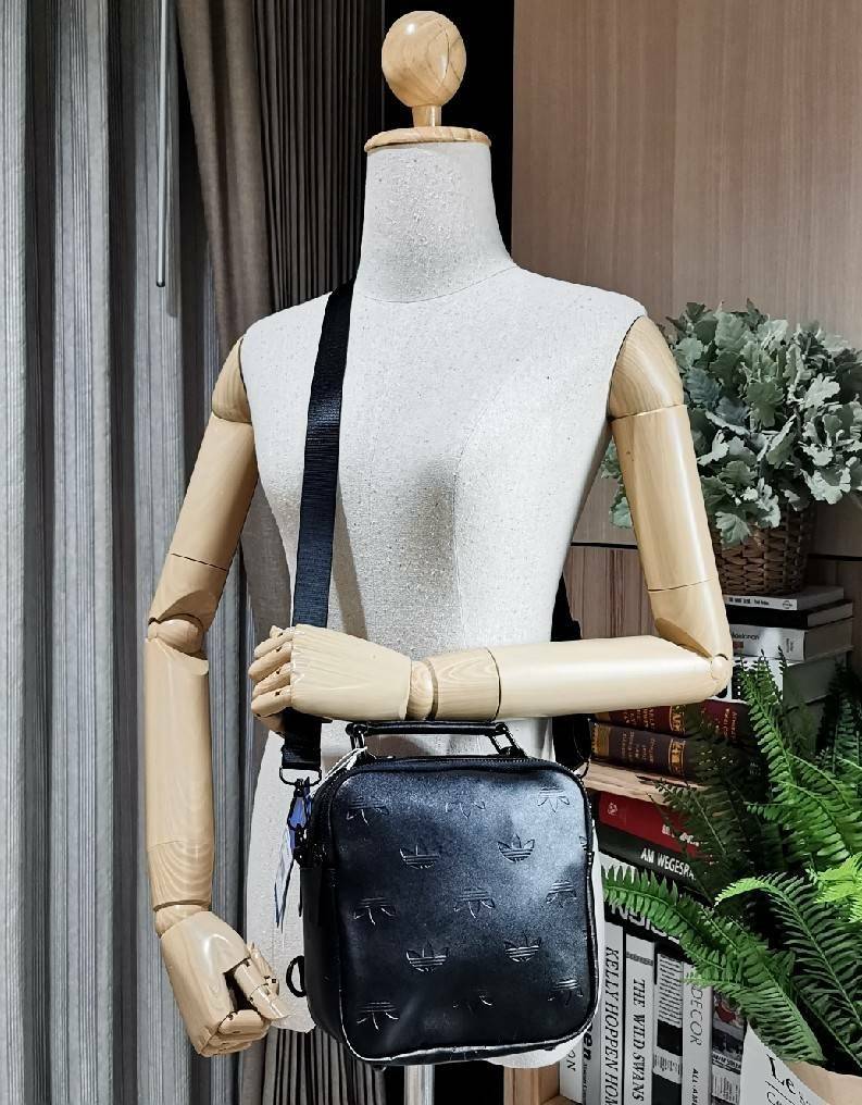 ADIDAS 2WAYS TOP HANDLE BAG กระเป๋าถือเเละสะพายเป้แบบ 2Ways ดีไซน์ทรงเหลี่ยมขนาดกำลังดีิ น้ำหนักเบา วัสดุหนังเรียบสวยสีดำปั้มโลโก้แบรนด์รอบใบ หูจับถนัดมือ มีช่องหลัก2ช่องแยกเป็นสัดส่วน เปิดปิดด้วยซิปสะดวกใช้ หัวซิปแบรนด์ ภายในมีโลโก้ มีสายสะพาย2เส้น สายถอ