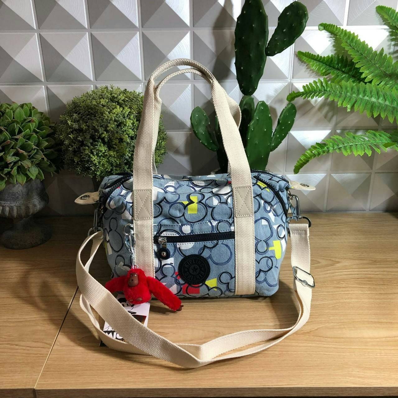 Kipling D ART MINI Collection Mickey กระเป๋าถืออเนกประสงค์ Art Mini จาก KIPLING ขนาดเล็กมีน้ำหนักเบา และช่องกระเป๋ากว้าง สะดวกในทุกการพกพาไปพร้อมคุณ มีมุมด้านข้างสามารถปรับได้ให้เข้ากับการใช้งานของคุณ โดยการรูดซิปลงเพื่อให้เป็นกระเป็นกระเป๋าสะพายดีไซน์เก๋