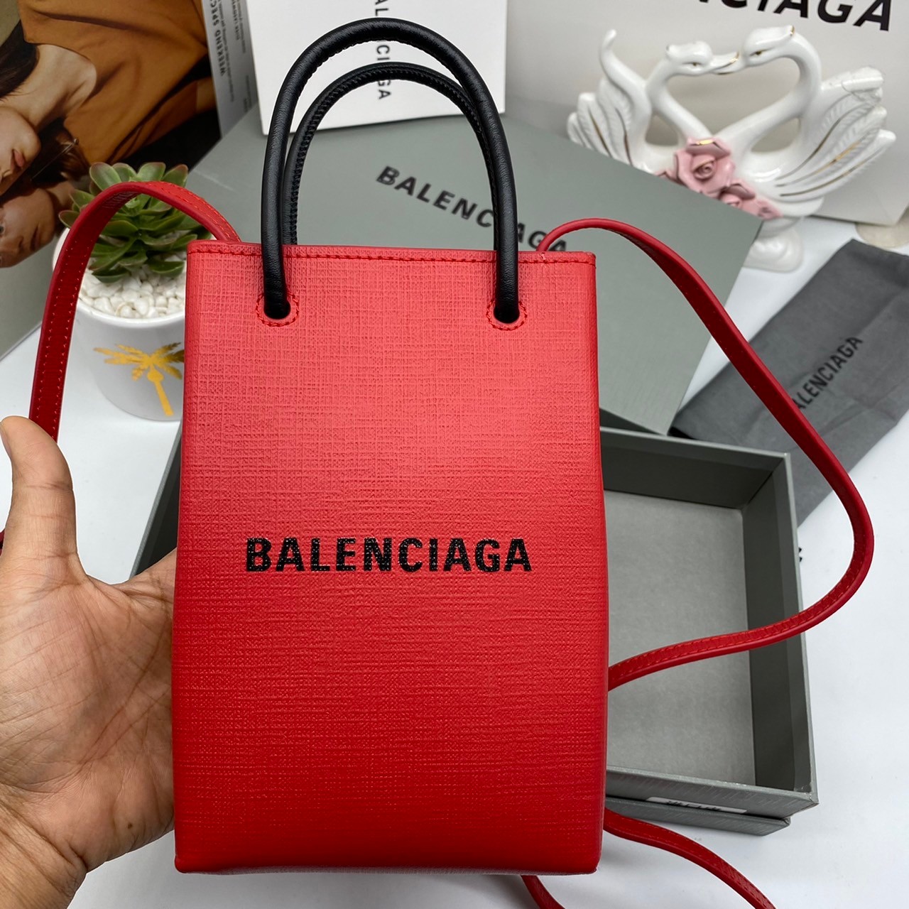 หนังแท้ BALENCIAGA Shopping Phone Pouch leather tote พกกระเป๋าช้อปปิ้งขนาดมินิ ไปทุกที่ในฤดูกาลนี้ ดีไซน์ที่ใช้ได้ทุกวันตั้งแต่หนังแบบมีเท็กซ์เจอร์ ภาพสินค้าถ่ายจากงานขายจริง ใช้งานต่างประเทศได้