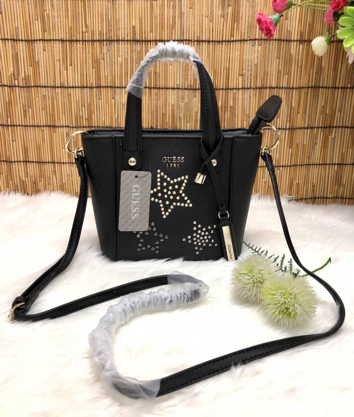 GUESS DELANEY MINI CROSSBODY BAG กระเป๋าถือหรือสะพายข้างได้ วัสดุหนังลาย saffiano ด้านหน้ามีโลโก้แบรนด์ พร้อมตกแต่งรูปดาว และ tag brand ห้อยที่หูกระเป๋า ตัวกระเป๋าเปิดแบบซิป ภายในโล่ง จุได้พอประมาณค่ะ มีช่องซิปอและช่องเล็ก มาพร้อม สายยาวปรับระดับได้ ราคาส