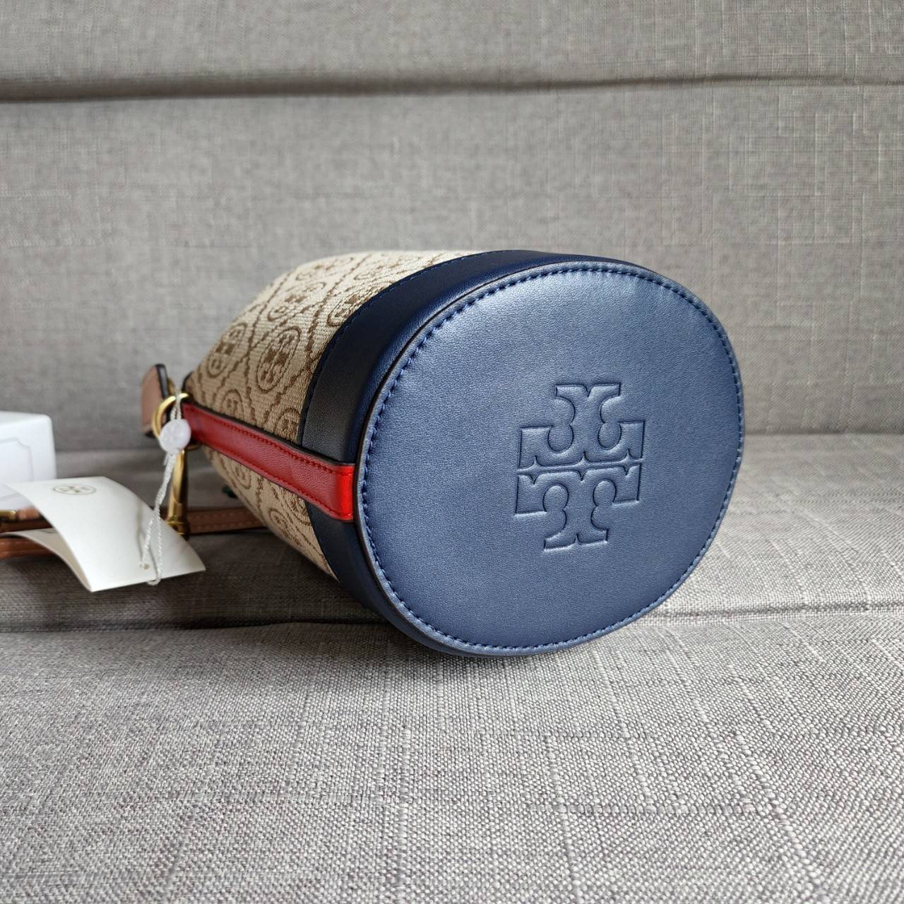 TORY BURCH T MONOGRAM COLORBlOCK JACQUARD MINI BUCKET BAG คอลเลคชั่นใหม่ล่าสุด ครอบครองก่อนใคร รุ่นบัคเก็ตทรงจีบ วัสดุ jacquard สลับหนังแท้ ตัดขอบข้างสีแดงทำให้ดูโดดเด่น หูจับหนังแท้ เปิด ปิด แบบหูรูด ภายในช่องโล่งกว้าง มาพร้อมสายสะพายข้างหนังแท้ ปรับระดั