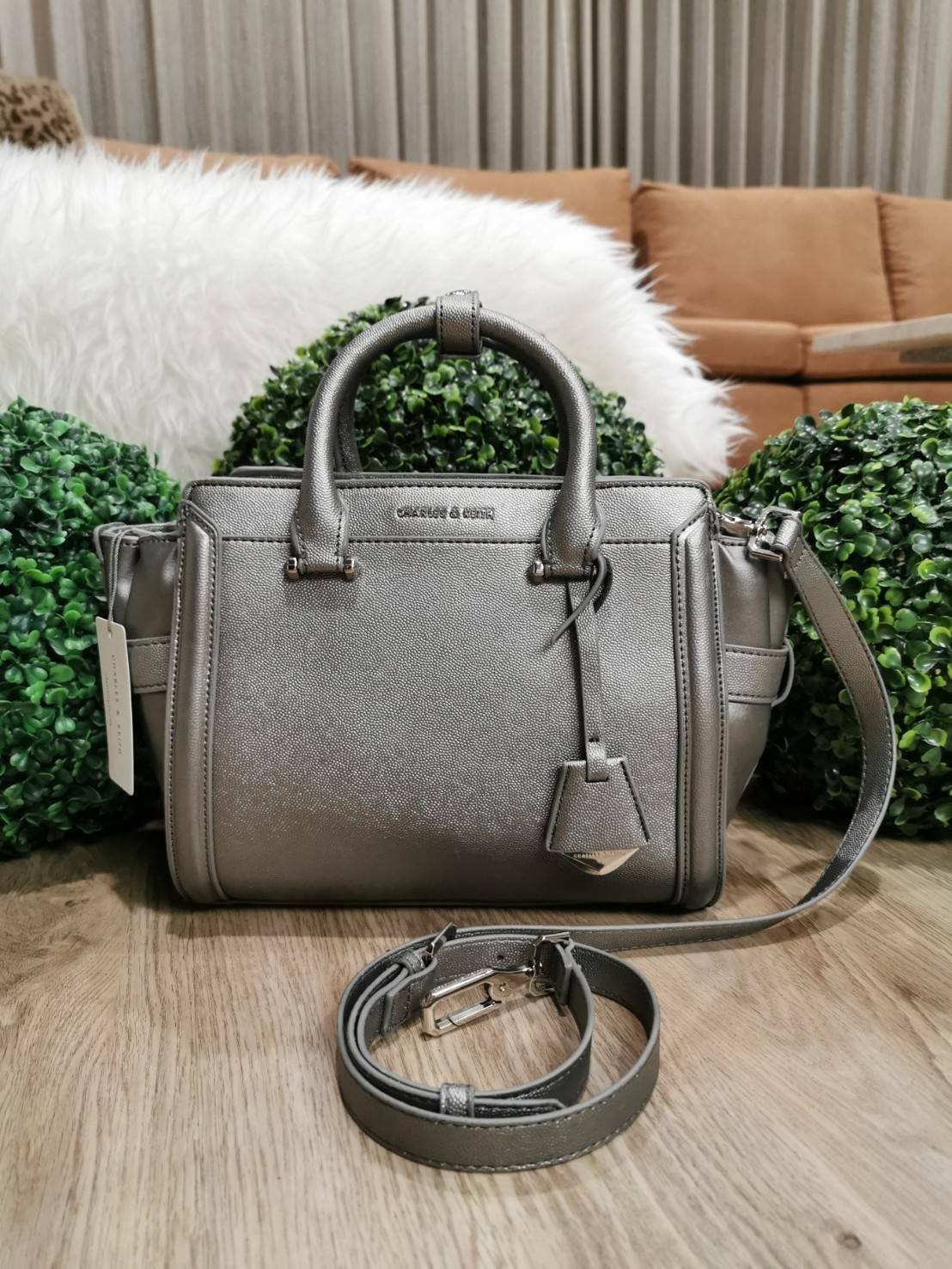CHARLES & KEITH SAFFIANO TRAPEZE BAG กระเป๋าถือหรือสะพายรุ่นยอดนิยมดีไซน์สวยหรูวัสดุหนังคาเวียร์อยู่ทรง ด้านข้างเเต่งหนังช่องตัดดูมีดีเทล ด้านหน้ามีโลโก้ ด้านหลังมีช่องซิป เปิดปิดด้วยซิปหัวซิปแบรนด์ หูจับเเข็งแรง พับลงได้ พร้อมสายสะพายหนังปรับระดับได้ถอดไ