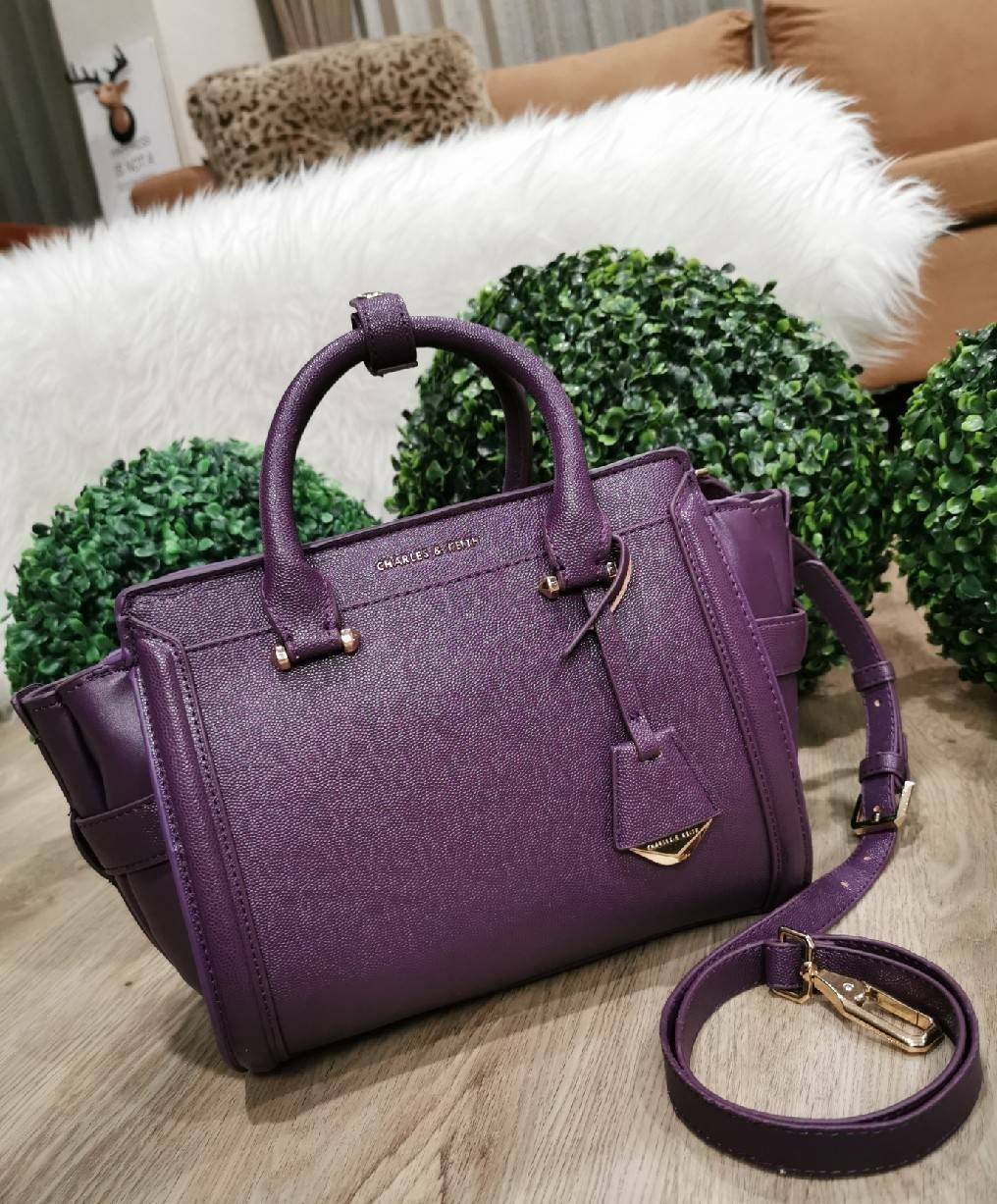 CHARLES & KEITH SAFFIANO TRAPEZE BAG กระเป๋าถือหรือสะพายรุ่นยอดนิยมดีไซน์สวยหรูวัสดุหนังคาเวียร์อยู่ทรง ด้านข้างเเต่งหนังช่องตัดดูมีดีเทล ด้านหน้ามีโลโก้ ด้านหลังมีช่องซิป เปิดปิดด้วยซิปหัวซิปแบรนด์ หูจับเเข็งแรง พับลงได้ พร้อมสายสะพายหนังปรับระดับได้ถอดไ