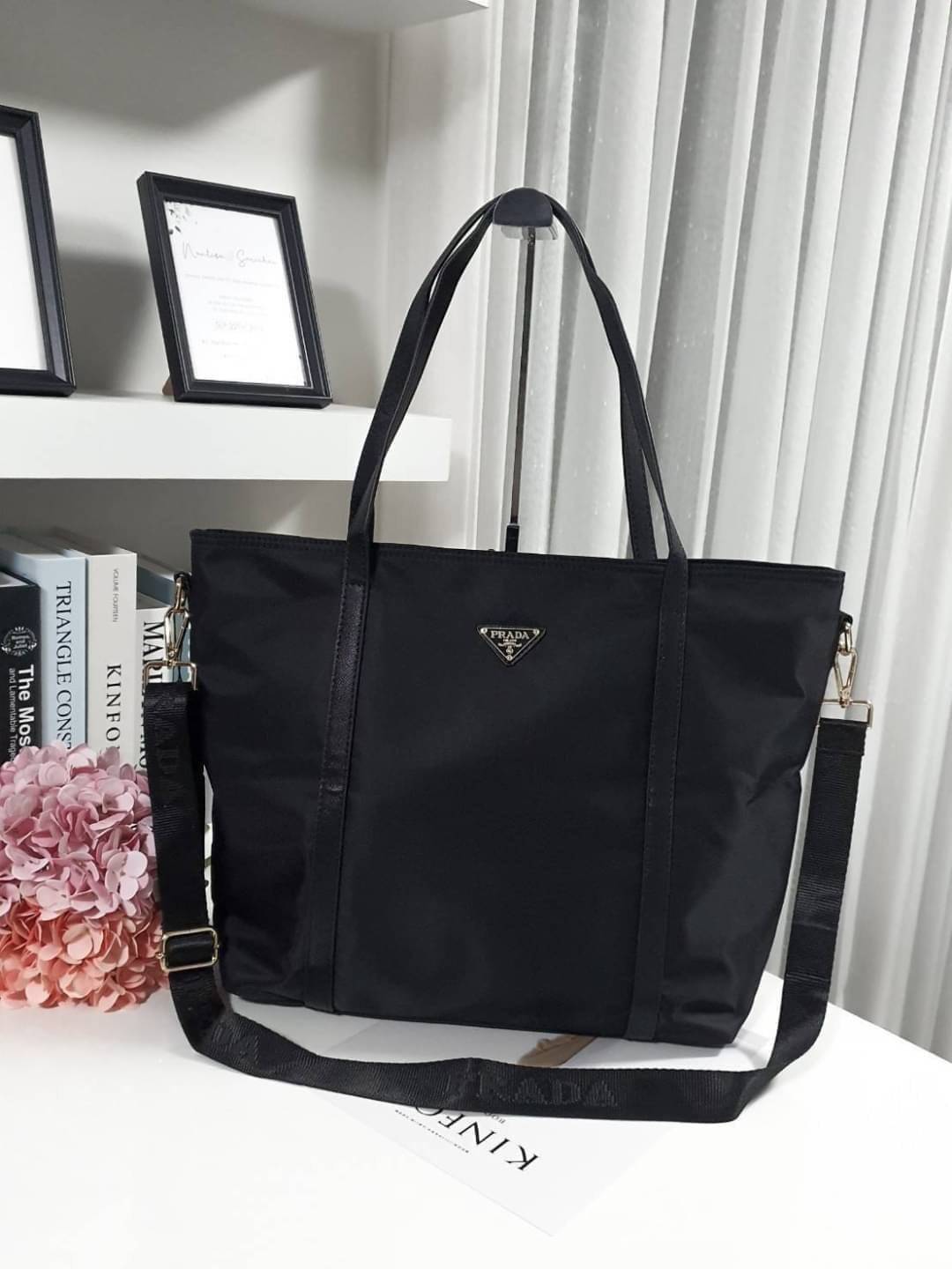 งานใบใหญ่ จากงานพรีเมี่ยมกิ้ฟ จากเคาเตอร์ต่างประเทศคะ แบรนด์ PRADA เป็น กระเป๋าผ้าไนล่อน ตามแบบฉบับของแบรนด์เลย หลงรักเลยคะ สะพายไหล่ได้ ถือก็สวยๆ ใช้แล้วสวยมากๆ มาพร้อมสายสะพายยาว ใส่ของได้เยอะเว่อร์ IPAD สมุด หนังสือ ขวดน้ำ ใส่ได้สบาย คุ้มราคามากคะ ห้าม