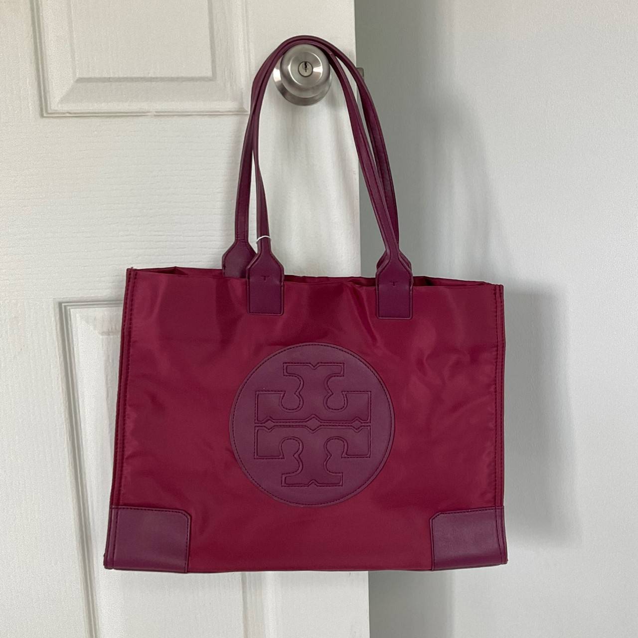 กระเป๋าทรงโท้ทใบใหญ่ TORY BURCH ELLA TOTE BAG วัสดุ NYLON ทั้งใบตัดด้วยหนังสีดำ แต่งโลโก้แบรนด์ด้านหน้า ด้านข้างมีกระดุม สามารถขยายทรงได้ ด้านในเปิดปิดด้วยกระดุมแม่เหล็กฝัง ช่องกว้างหลักหนึ่งช่องและช่องซิปอีกช่อง สามารถใส่แล็ปท็อปได้สบาย ใบใหญ่เว่อวัง ไอเ
