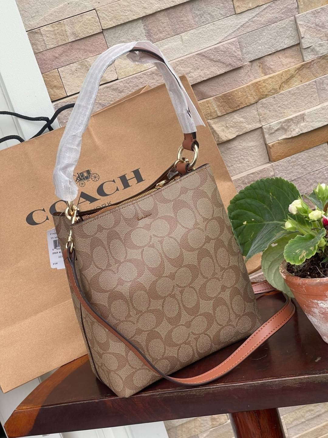 COACH SMALL TOWN BUCKET BAG IN SIGNATURE สำหรับสาวแฟชั่นที่ชอบรายละเอียดชิคๆ ดีไซน์สุดเก๋ แนะนำเลยสำหรับกระเป๋าทรงบักเก็ตใบนี้ เชื่อว่าสาว ๆ หลายคนชื่นชอบ เป็นไอเทมที่สามารถแมทช์ได้กับเสื้อหลากหลายสไตล์ บรรจุของได้เยอะโดยที่กระเป๋าไม่เสียทรง แบ่งช่องใช้งา