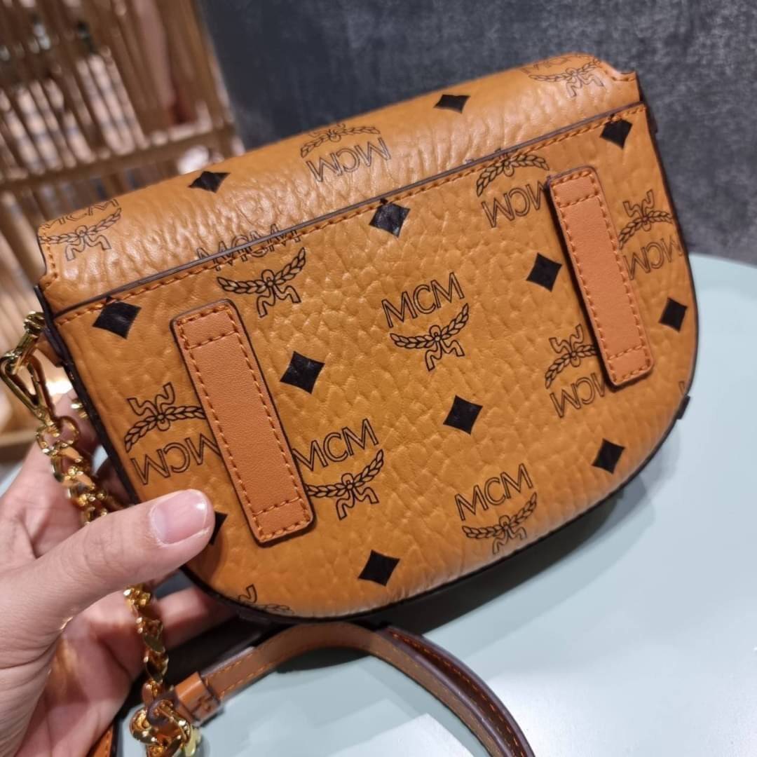 M.C.M MINI PATRICIA CROSSBODY IN VISETOS กระเป๋าสะพายไซส์มินิ แรงดีไม่มีตกน้า คอลเลคชั่นนี้ดีไซน์แปลกใหม่ ทรงโค้งมน สวยหรู ด้านข้างตกแต่งหมุดทองรอบใบ วัสดุตัวกระเป๋าเป็นหนังแคนวาสคุณภาพดี ภายในเป็นหนังกลับสีส้มโดดเด่นเป็นเอกลักษณ์ มีช่องใส่บัตรแยกให้ เปิด