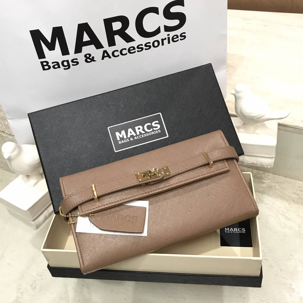 พร้อมส่งความสวย! NEW ARRIVAL! MARCS PADLOCK LONG WALLET กระเป๋าสตางค์ใบยาววัสดุหนัง Saffiano สวยหรูโดดเด่นด้วยสายหนังรัดกระเป๋าด้านหน้าสไตล์ Birkin ภายในมีโลโก้และมีช่องแบ่งหลายช่องเป็นสัดส่วนช่องใส่บัตรหลายช่อง มีช่องซิปสำหรับใส่เหรียญ ใส่ธนบัตร และ ipho