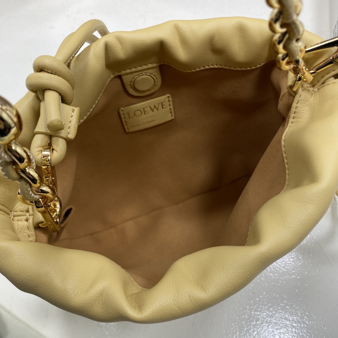 ORI หนังแท้ | LOEWE Mini Flamenco purse in mellow nappa leather / Loewe Bucket Bag กระเป๋าสะพายทรงบัคเก็ตไซส์มินิ หนังเรียบสวยหรู เรียบง่าย หนังแท้ผิวสัมผัสนุ่มมือ น้ำหนักเบาและนุ่มสบาย ดีไซน์จับจีบ เชือกผูกแบบปมโบราณ และสายโซ่รูปโดนัท