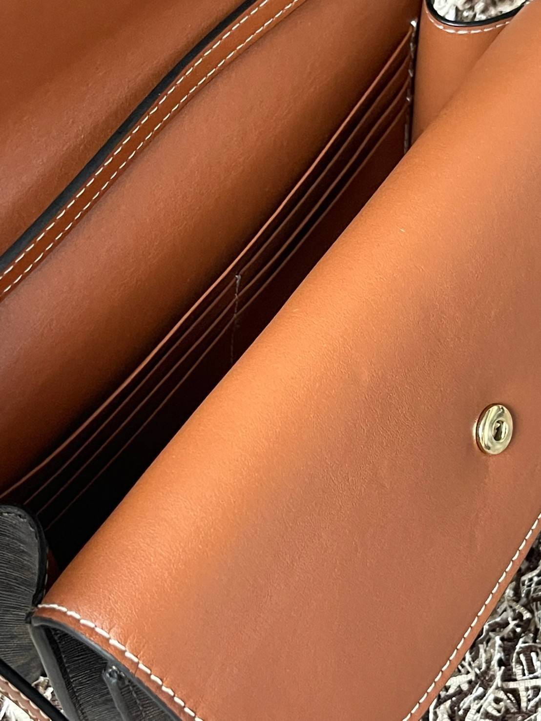 CELINE WALLET ON STRAP IN TRIOMPHE CANVAS กระเป๋าสะพายไหล่สุดเก๋ใบนี้ผลิตจากผ้าใบเคลือบอย่างดีพร้อมขอบหนังสีน้ำตาล กระเป๋ามีสายสะพายหนังสีน้ำตาลพร้อมฮาร์ดแวร์สีทอง ถอดสายออกเพื่อเป็นกระเป๋าถือทรงคลัชท์เปลี่ยนลุคช์ ลวดลายtriomphe ความเป็นแบรนด์ CELINE ได้อ