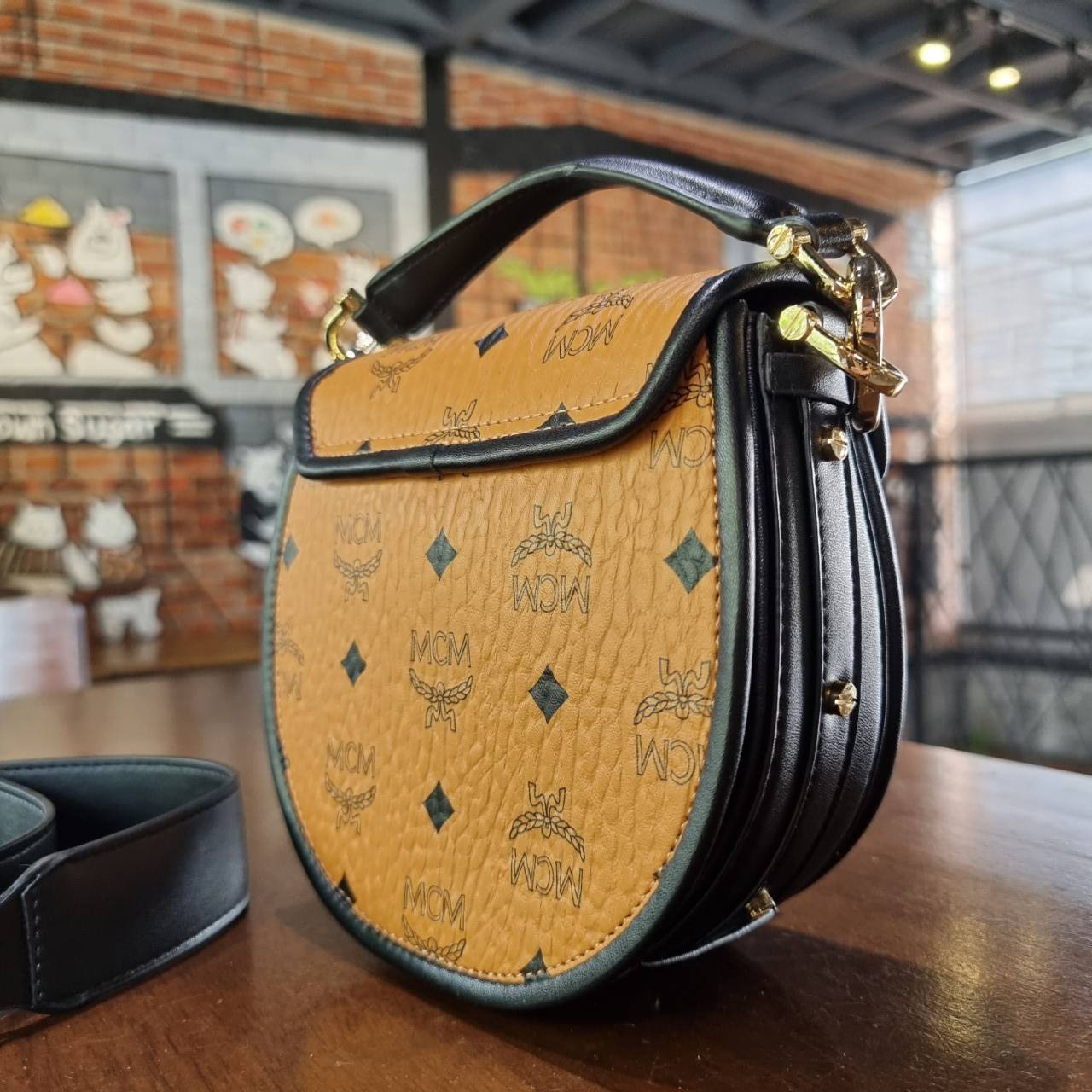 M.C.M MINI PATRICIA SHOULDER BAG IN VISETOS LEATHER BLOCK อัพเลเวลกระเป๋าของคุณด้วยไอเท็มนี้ไปเลยจ้า กระเป๋าสะพายทรง saddle ที่เก๋ไม่ซ้ำใคร ดีไซน์ขอบสีดำเพิ่มความยูนิค สวยสะดุดตา วัสดุหนังแคนวาสคุณภาพดี มาพร้อมสายสะพายหนังสีดำเรียบ และหูจับในตัว ทำให้ใช้ง