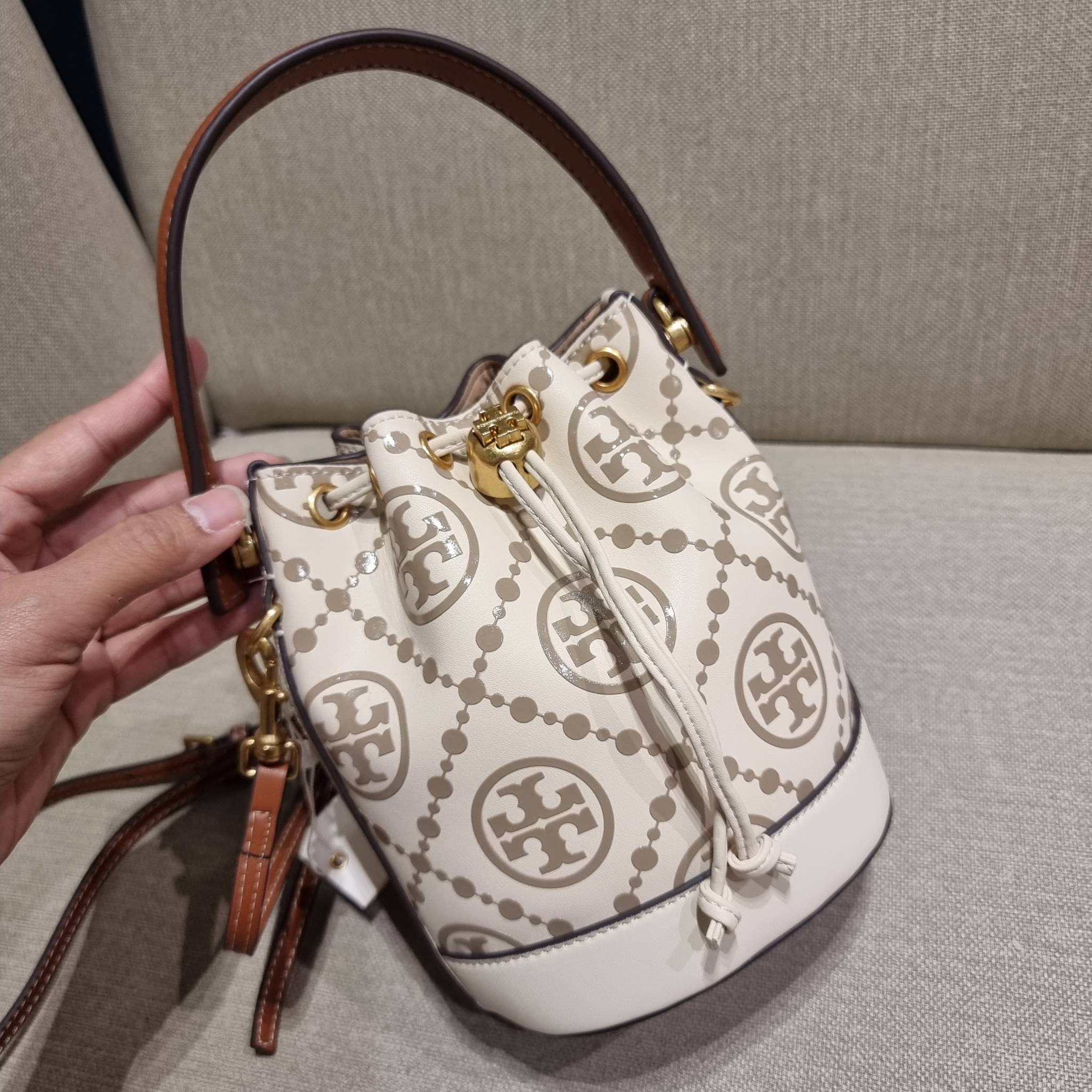 TORY BURCH T MONOGRAM EMBOSSED MINI BUCKET BAG คอลเลคชั่นใหม่ กับกระเป๋าบัคเก็ตทรงยอดนิยม ในไซส์มินิ ดีไซน์ใหม่ล่าสุด สวยลูกคุณหนู หรูหรา!! ด้วยดีเทลผิวลายนูนลวดลายเอกลักษณ์ วัสดุหนังแท้ ปากกระเป๋ารูดเปิด-ปิดได้ มีหูจับในตัว สะดวกใช้ไปอีก และมีสายสะพายข้า