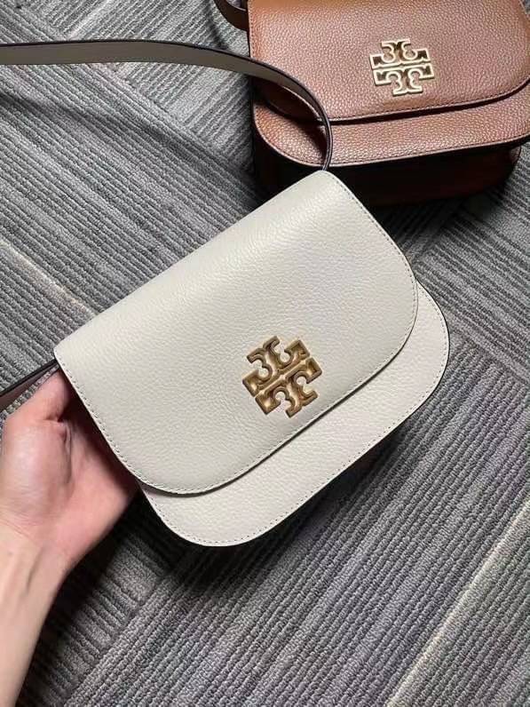 TORY BURCH BRLTTEN SMALL SADDLE BAG / Tory Burch Britten Flap Shoulder Bag กระเป๋าสะพายข้าง วัสดุหนังแกะแท้ ด้านหน้าประดับโลโก้แบรนด์ เปิด-ปิดกระเป๋าแบบกระดุมแป็กแม่เหล็กแน่นหนา ภายในมีช่องหลัก ใส่กระเป๋าเงินใบกลาง มือถือได้ทุกรุ่น มีช่องแยกใส่ของจุกจิกอี