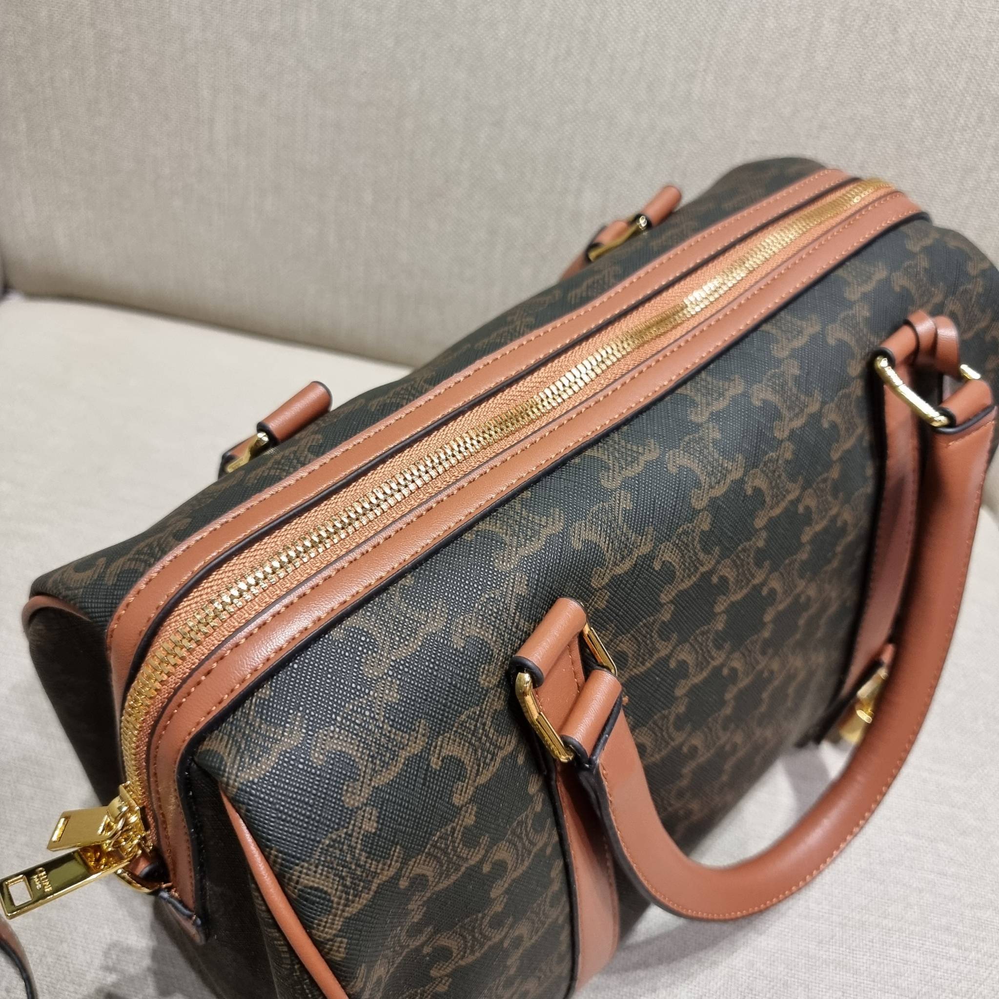 CELINE BOSTON BAG IN TRIOMPHE CANVAS AND CALFSKIN ยอดฮิตกับลวดลายเอกลักษณ์ สุดคลาสสิค กับกระเป๋ากึ่งเดินทาง ไซส์กำลังดี ที่สามารถใช้ได้ทั้งหนุ่มๆและสาวๆ วัสดุหนังแคนวาสตัดสลับหนังแท้ เปิด-ปิดด้วยซิป ใช้งานสะดวก และยังมีพวงหนังห้อยและแม่กุญแจล็อคซิปได้ มาพ