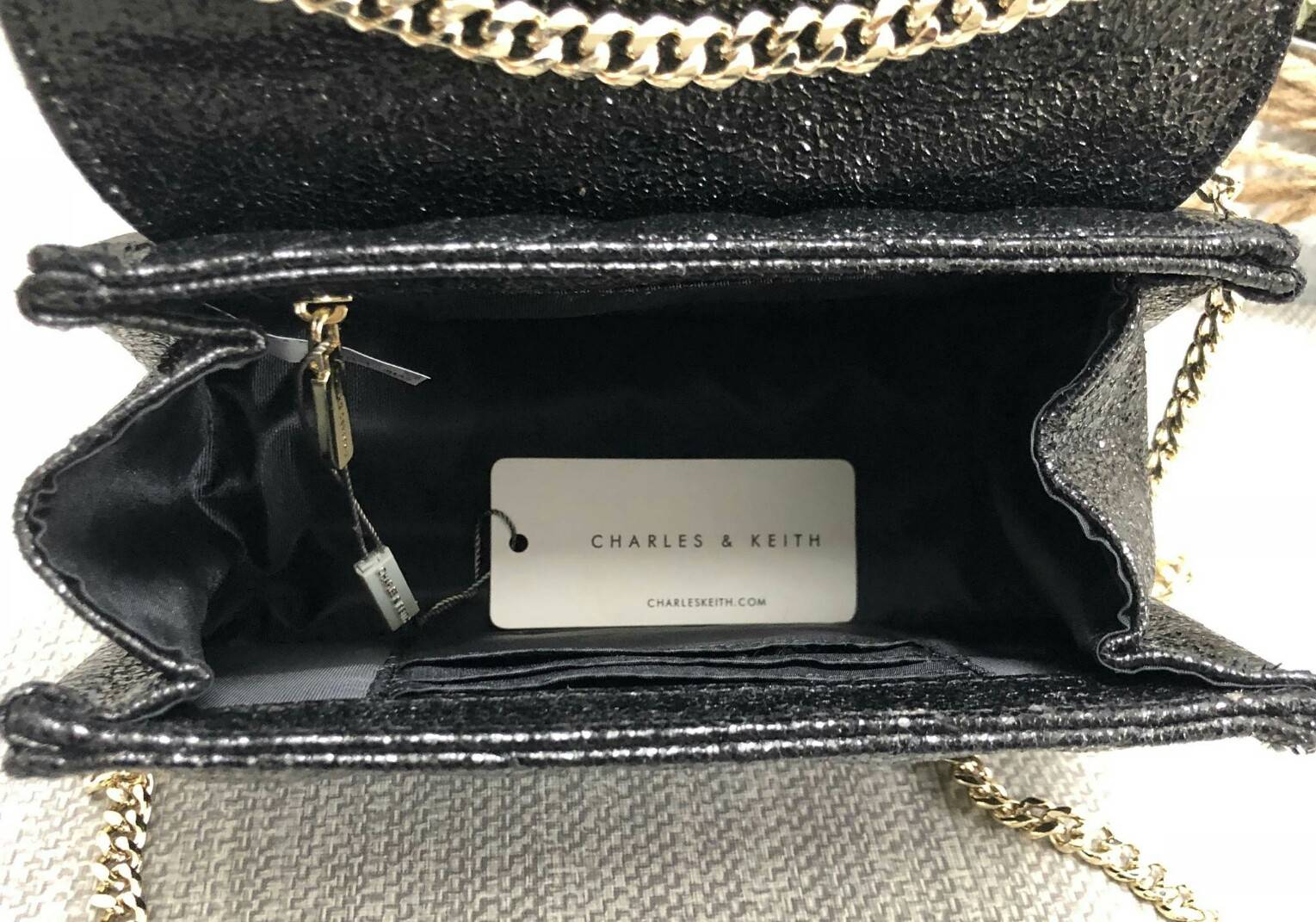 CHARLES & KEITH TASSEL DETAIL SHOULDER BAG กระเป๋าสะพายข้าง ทรงน่ารัก ด้านหน้ามีพู่ห้อย เปิดปิดกระเป๋าแบบแม่เหล็ก ด้านในโล่ง มีช่องซิป 1 ช่อง และช่องใส่บัตรได้ 3 ช่องค่ะ สายสะพายโซ่สีทองหรูหราค่ะ