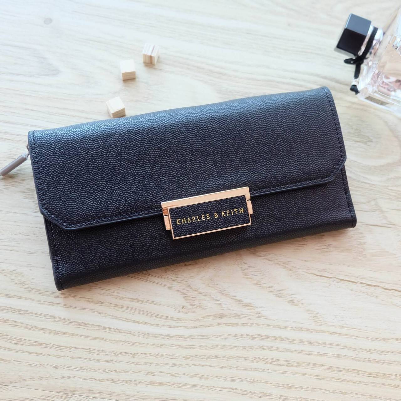 Charles & Keith Push-Lock Long Wallet กระเป๋าเงินใบยาววัสดุหนังลายคาร์เวียร์ ด้านหน้าปั๊มโลโก้แบรนด์ เปิดปิดแบบตัวล็อก ด้านในมีช่องซิปใส่เหรียญและธนบัตร ด้านหลัง มีตัวล็อคแบบกระดุม จุบัตรได้ถึง 12 ใบ รุ่นนี้สวยหรูเกินราคา ด้านหน้าเปิด - ปิดด้วยตัวกดล็อคทั