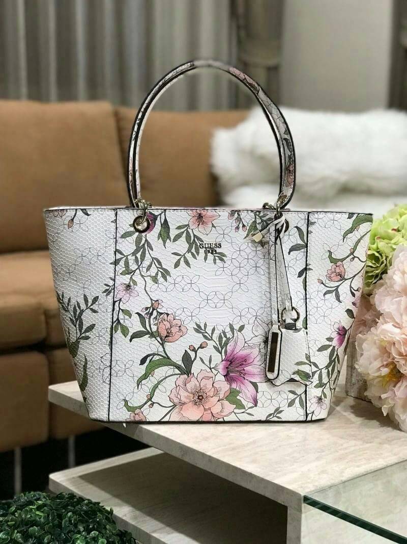 GUESS PRINTED KAMRYN FLOWERS SHOPPER BAG (SIZE L) กระเป๋าสะพายจาก GUESS FACTORY หนังสวยอยู่ทรงปริ้นลายดอกไม้คอลเลคชั่นล่าสุดใบใหญ่กำลังดี ใส่สัมภาระได้จุใจ น้ำหนักเบา ด้านหน้าประดับโลโก้แบรนด์อะไหล่เงินพร้อมพวงกุญแจแบรนด์ห้อยที่หูหิ้วถอดเเยกใช้ได้ หูหิ้วพ