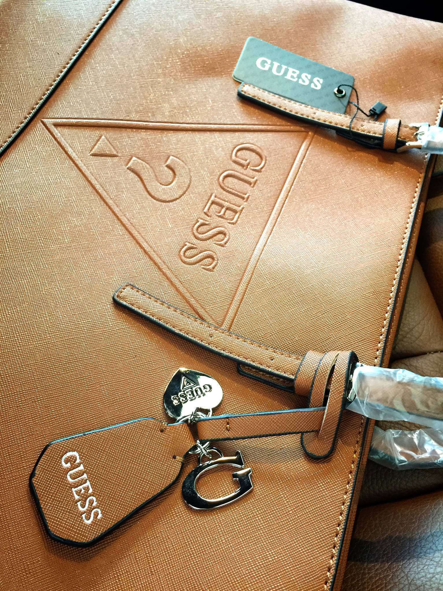 Guess Saffiano Shopping Bag กระเป๋าถือและคล้องบ่าทรงช้อปปิ้งใบใหญ่ หนังSaffiano ใส่เอกสารขนาด A4 ได้ จุของได้เยอะ ด้านหน้าสลักแบรนด์หนังลายนูนพร้อมประดับtagสายหนังถอดออกได้ เปิดปิดด้วยซิปเดียวด้านบน ภายในบุผ้าติดโลโก้ มีช่องเล็กและข่องใส่โทรศัพท์ เรียบง่า