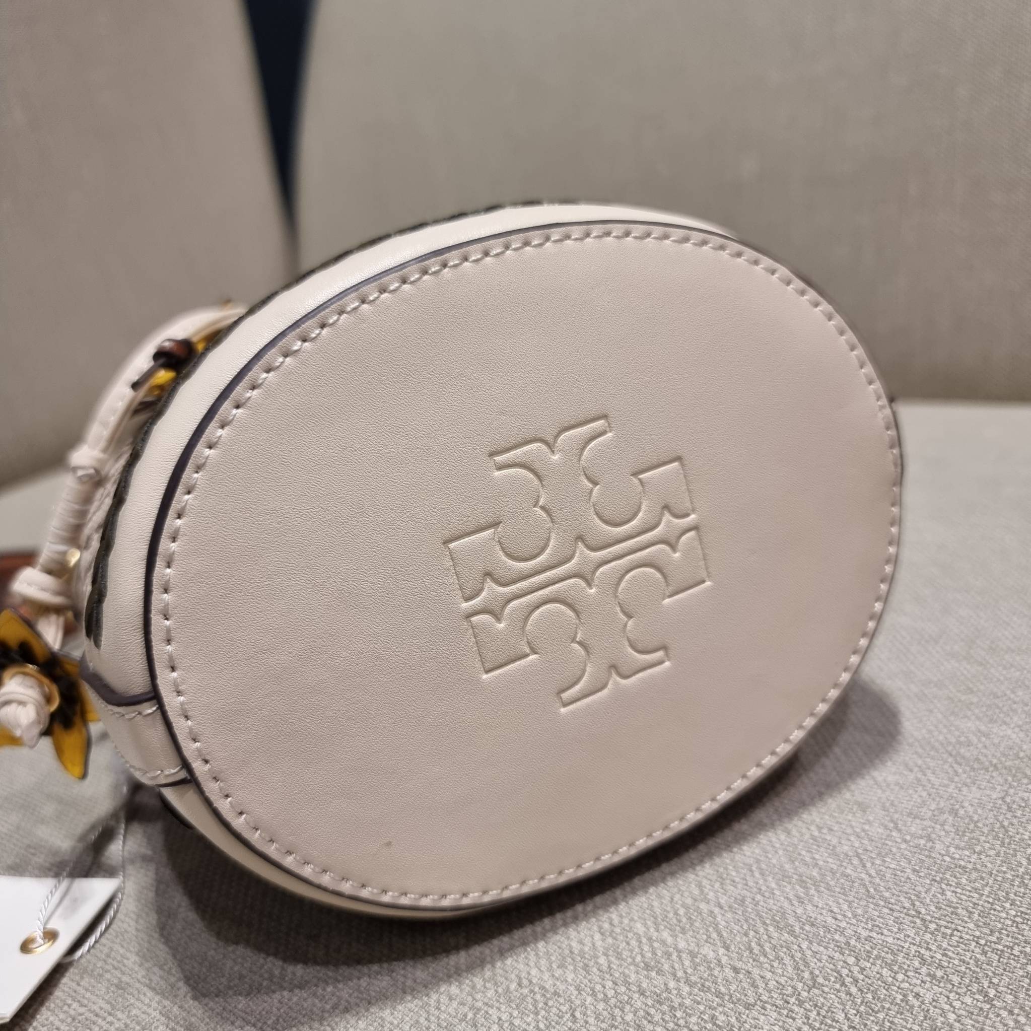 TORY BURCH MINI T MONOGRAM FLORAL BUCKET BAG คอลเลคชั่นใหม่ พร้อมเสิร์ฟความสวยให้ถึงบ้าน!! กระเป๋าบัคเก็ตทรงยอดนิยม ไซส์มินิ ดีไซน์ใหม่ล่าสุด สไตล์งานคราฟ มีลูกเล่นประดับดอกไม้กับตัวกระเป๋า และตัวรูดสาย วัสดุผ้า jacquard ตัดสลับหนังแท้ หูจับและขอบกระเป๋าต