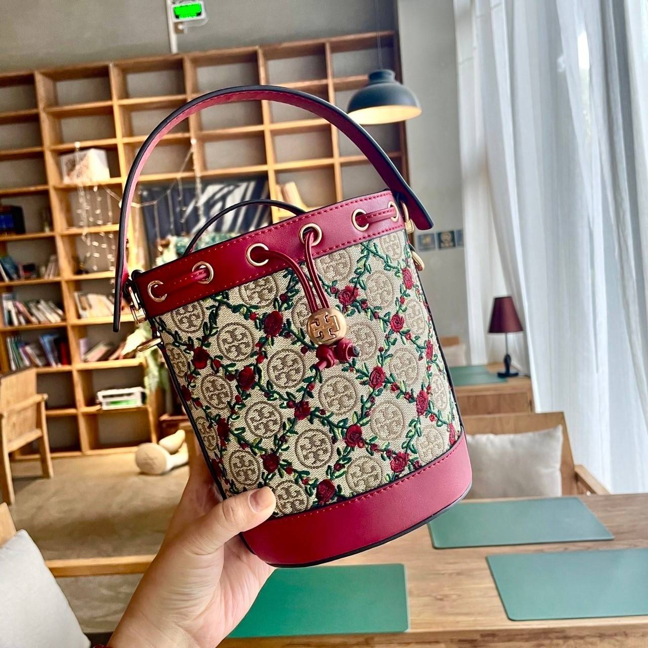 Mini : Tory Burch T Monogram Embroidered Mini Bucket Bag Hazelnut กระเป๋าทรงถังขนาดเล็ก เป็นแพทเทิร์นคลาสสิคที่ได้รับแรงบันดาลใจจากการควิลท์แบบดั้งเดิมของเพนซิลเวเนีย คอลเล็คชั่นบอกเล่าความมีสไตล์เหนือกาลเวลา ลายดอกกุหลาบสีแดงลายปักษ์ วัสดุผ้าสว๊อตซ์วินเท