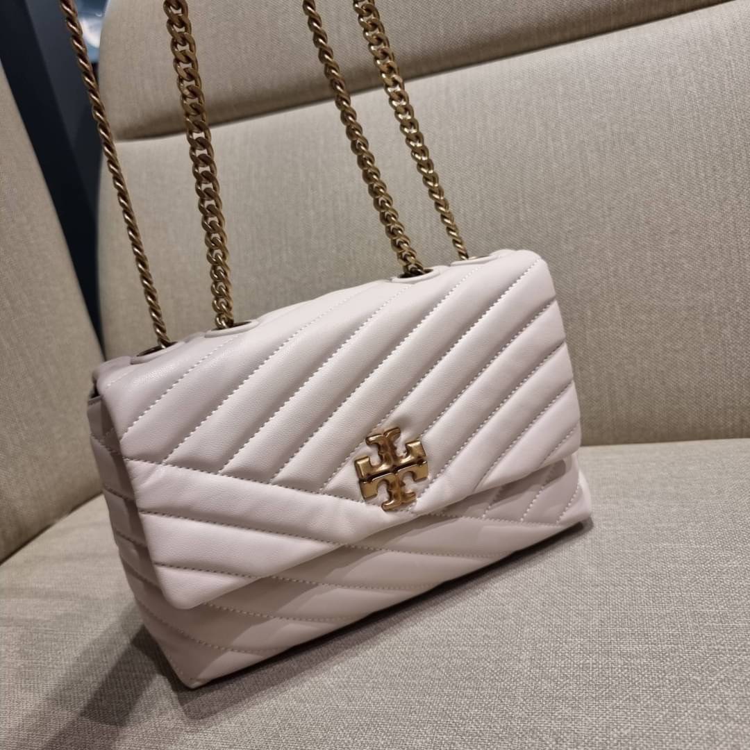 TORY BURCH KIRA CHEVRON CONVERTIBLE SHOULDER BAG (SMALL / MEDIUM) กระเป๋าสะพายรุ่นยอดฮิต ไซส์คลาสสิค ที่ใช้ยังไงก็ดูหรู ดีไซน์เฉพาะตัว วัสดุหนังแกะ สัมผัสนิ่ม เปิด-ปิดด้วยกระดุมแม่เหล็ก ภายในเป็นช่องโล่ง ใส่กระเป๋าสตางค์ มือถือ เครื่องสำอางค์ พาวเวอร์แบงค